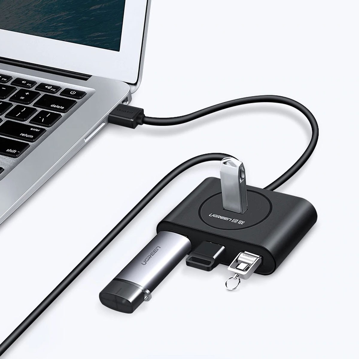 Czarny koncentrator USB z dwoma pendrive'ami i kablem podłączonym do laptopa.