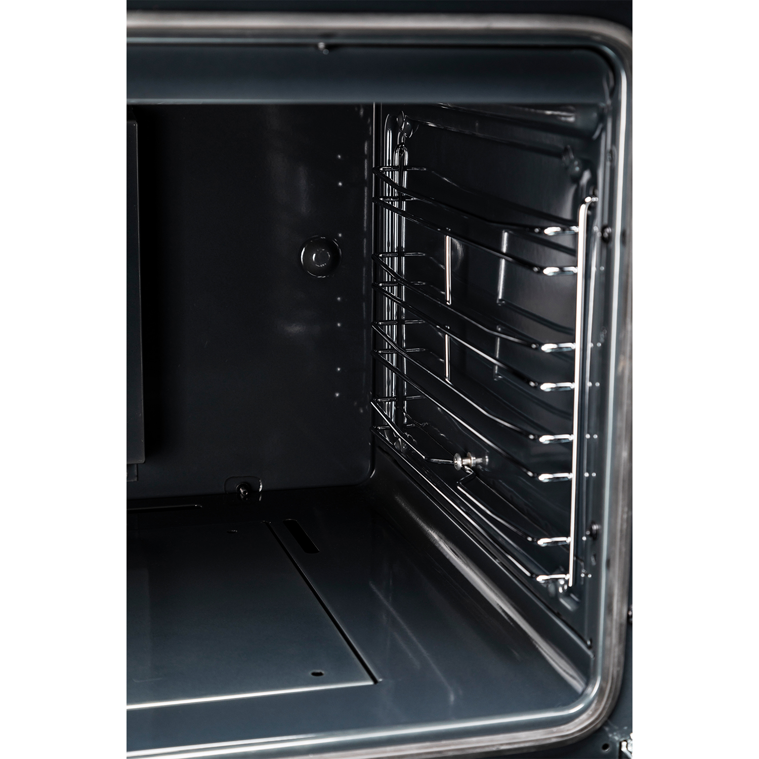 Interno di un forno scuro con griglie metalliche e una superficie inferiore liscia.