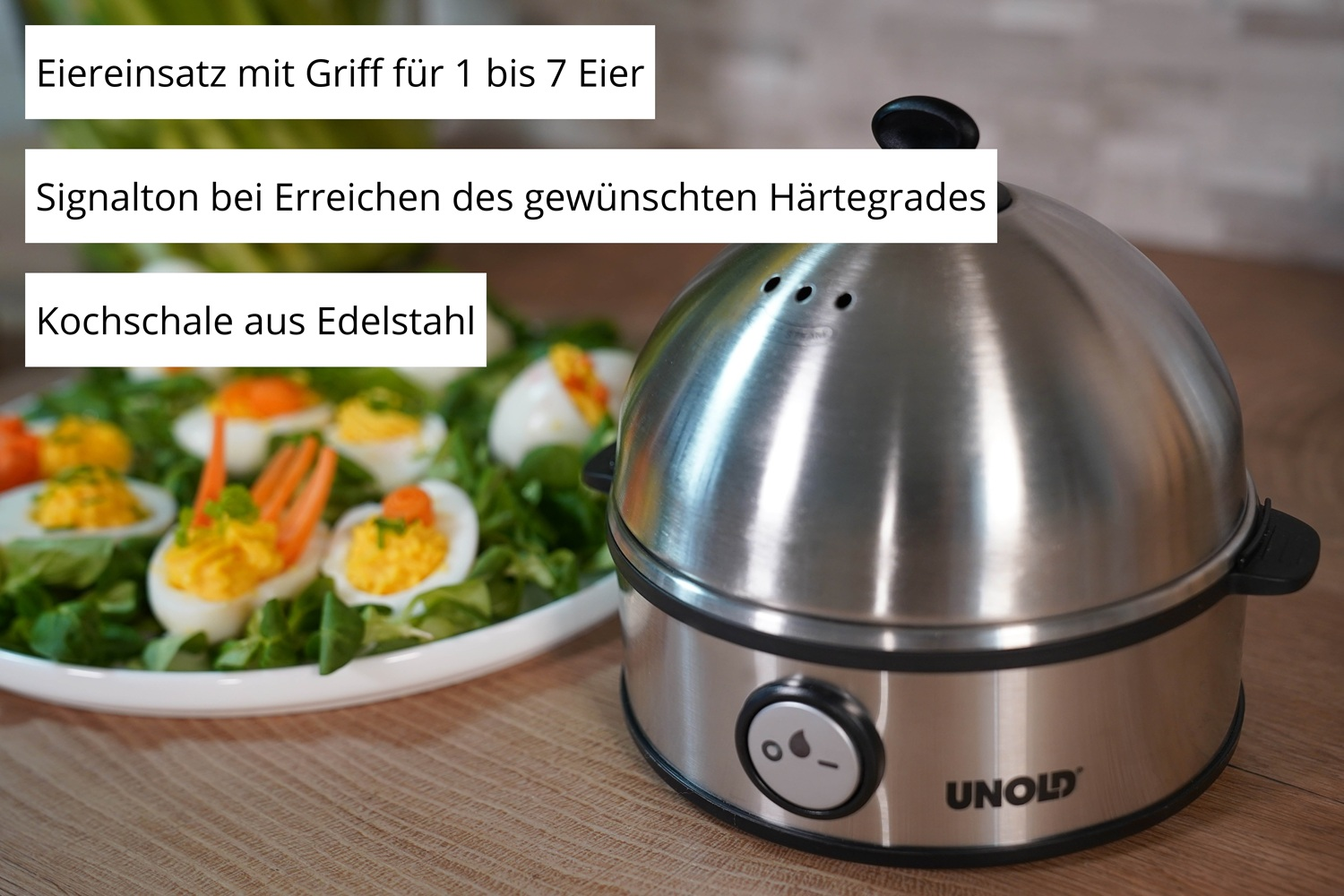 Ein Edelstahl-Eierkocher mit einem Teller gefüllter Eier daneben.