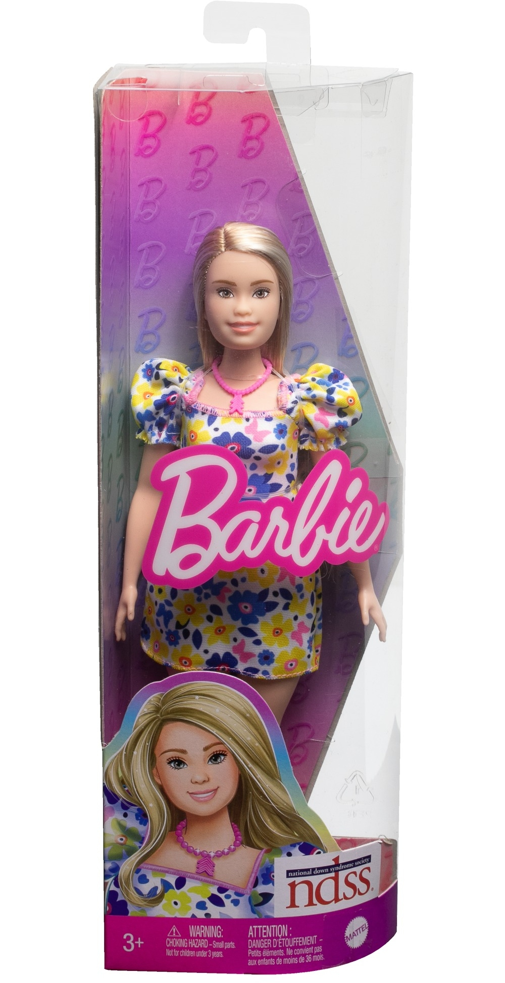 Barbie-Puppe in einer Schachtel mit Blumenkleid und pinker Halskette. Schachtel mit Barbie-Logo.