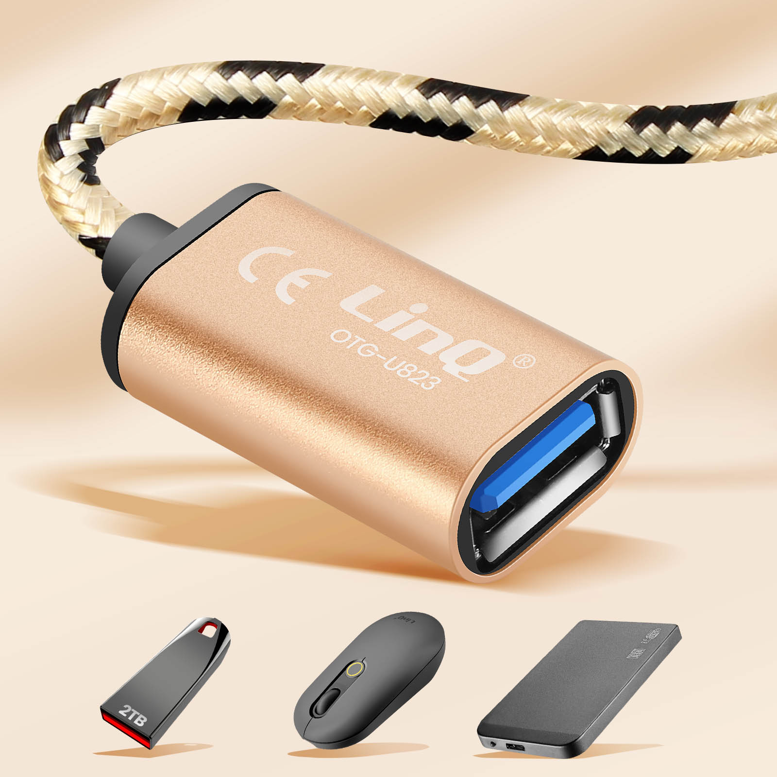 Adattatore OTG dorato con cavo intrecciato e porta USB. Sotto: unità USB da 2TB, mouse nero, hard disk esterno.