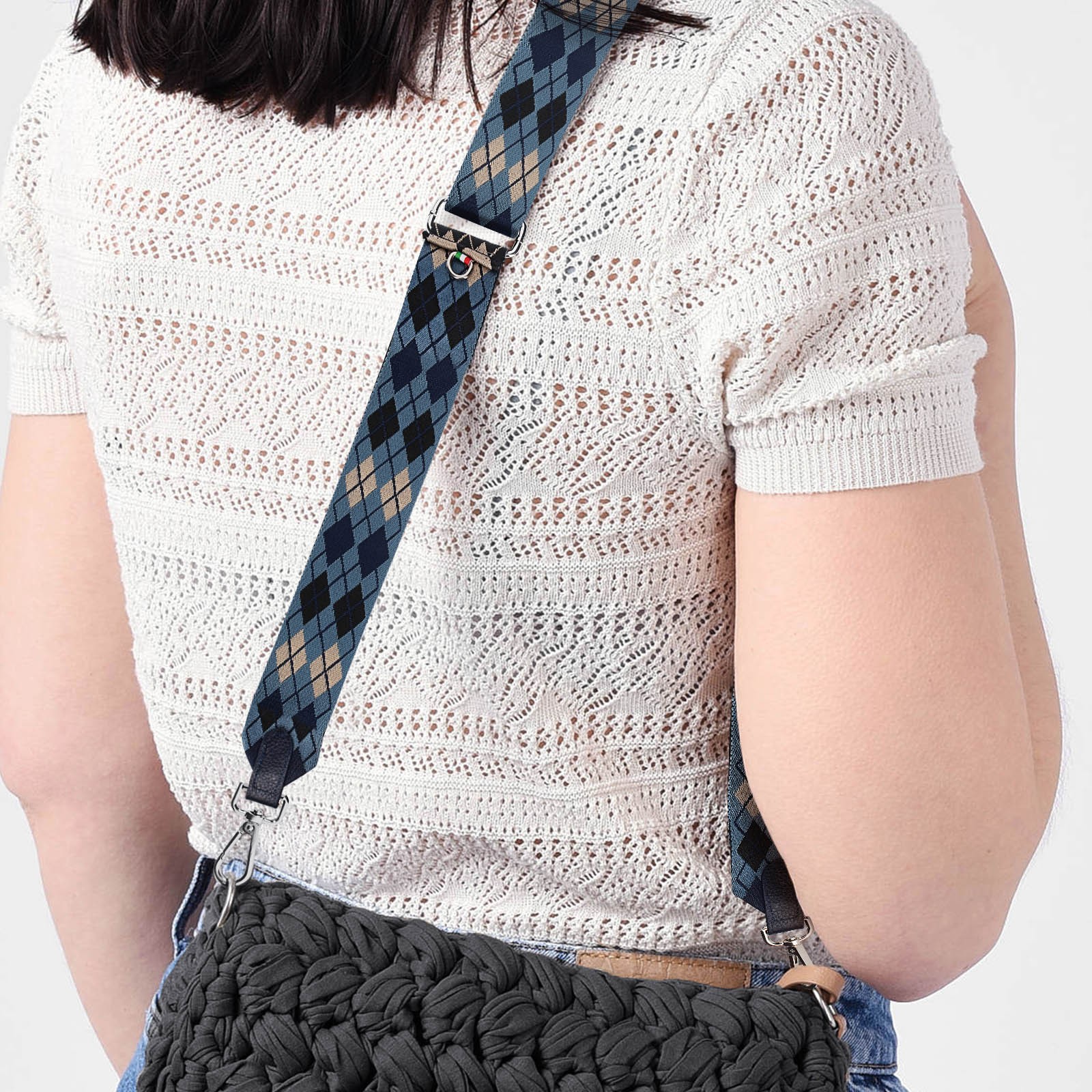 Una persona indossa un top in maglia chiara con tracolla a rombi.