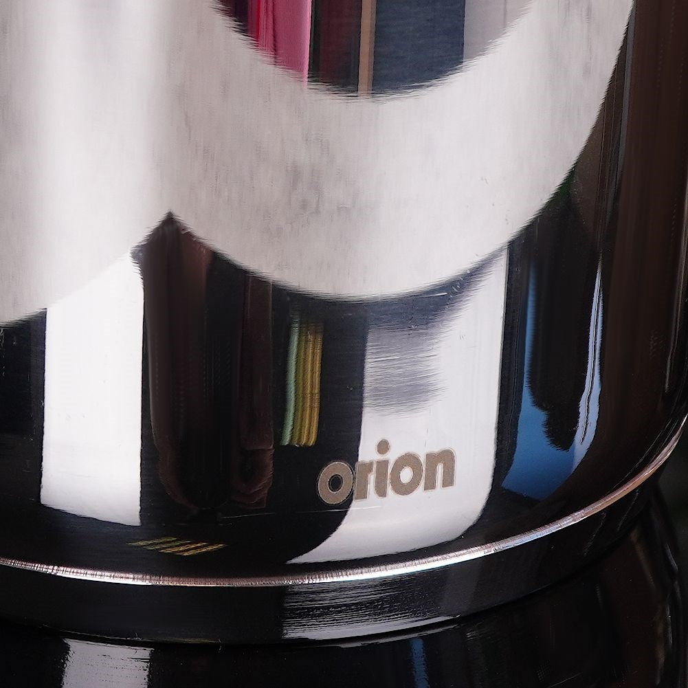 Primer plano de una olla metálica brillante con la palabra "orion" impresa.