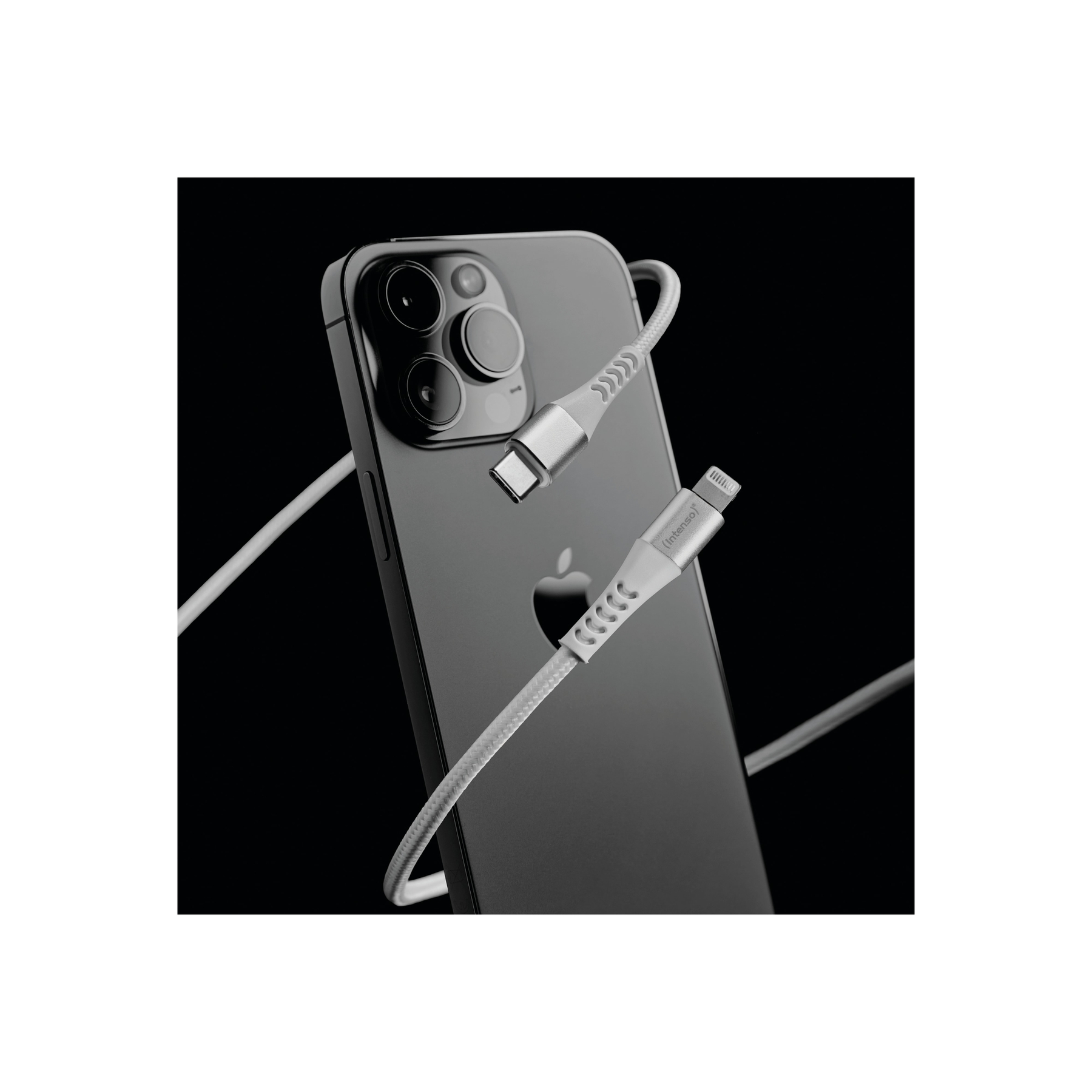 Un câble de chargement argenté avec connecteurs USB-C et Lightning repose sur un iPhone noir.