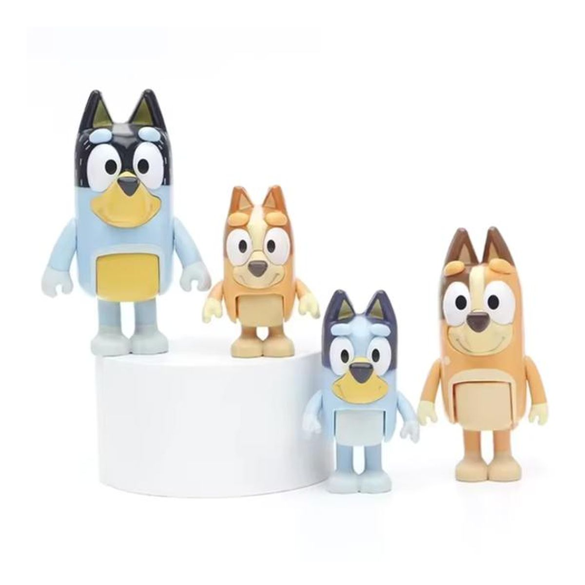 Quatre figurines de chien Bluey de différentes tailles : deux bleu clair, deux beiges. Fond blanc.