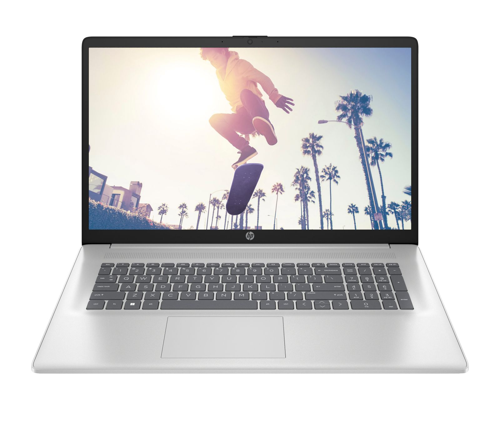 Laptop argento mostra uno skateboarder a mezz'aria con palme.
