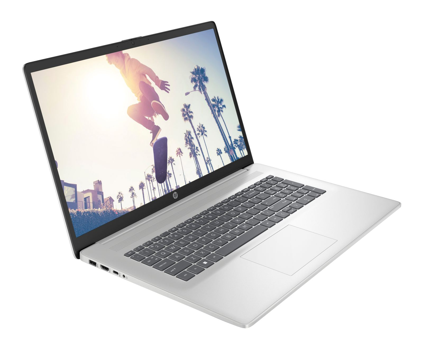 Laptop HP argentato che mostra uno skater che salta davanti a palme.