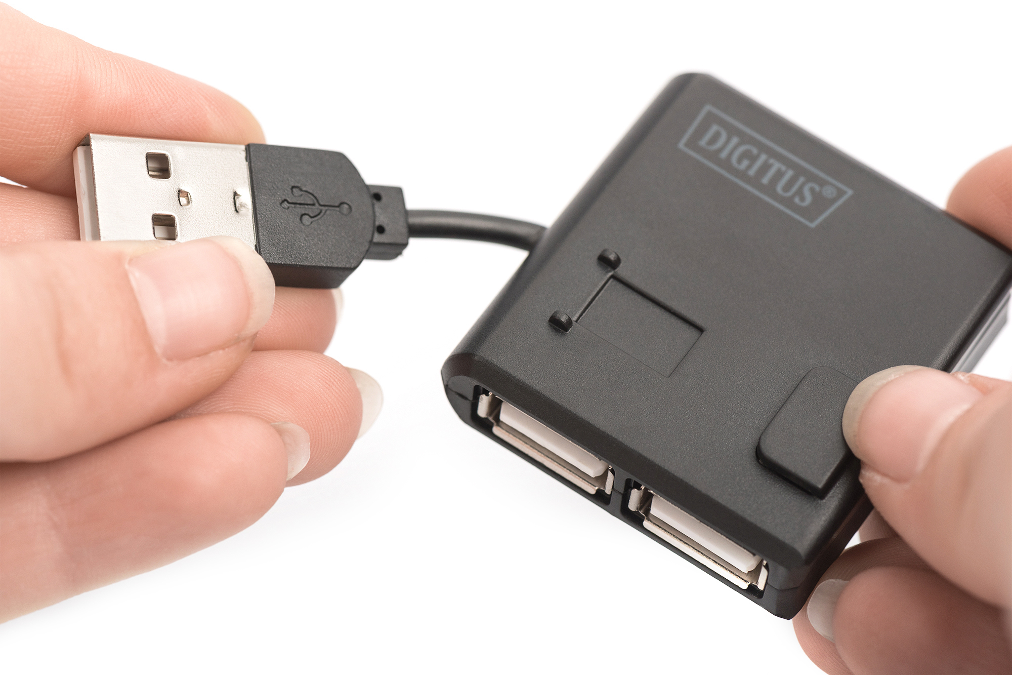 Bir el USB fişini, diğeri dört portlu siyah bir USB hub'ını tutuyor.