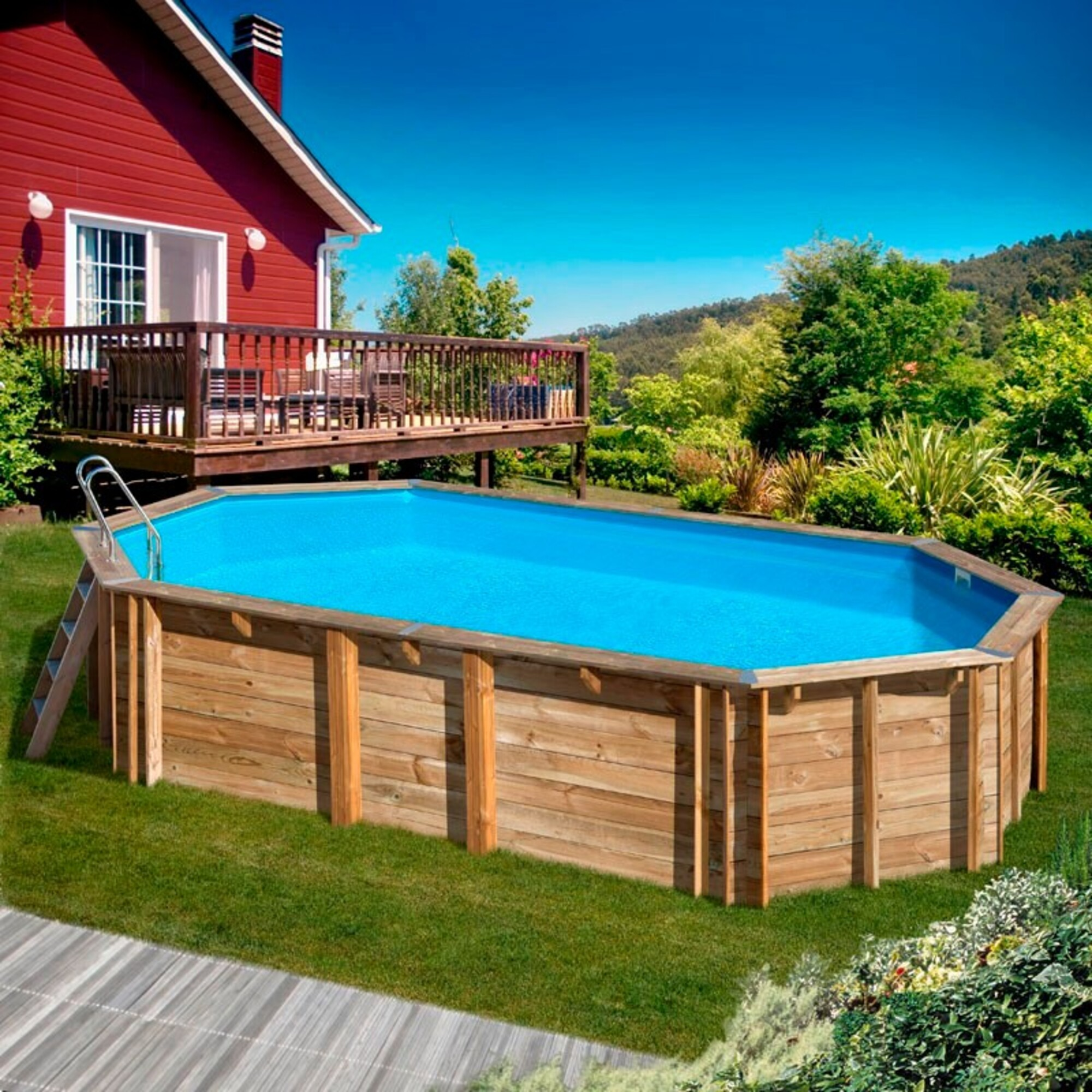 Una piscina de madera con agua azul se asienta sobre césped verde junto a una casa roja.