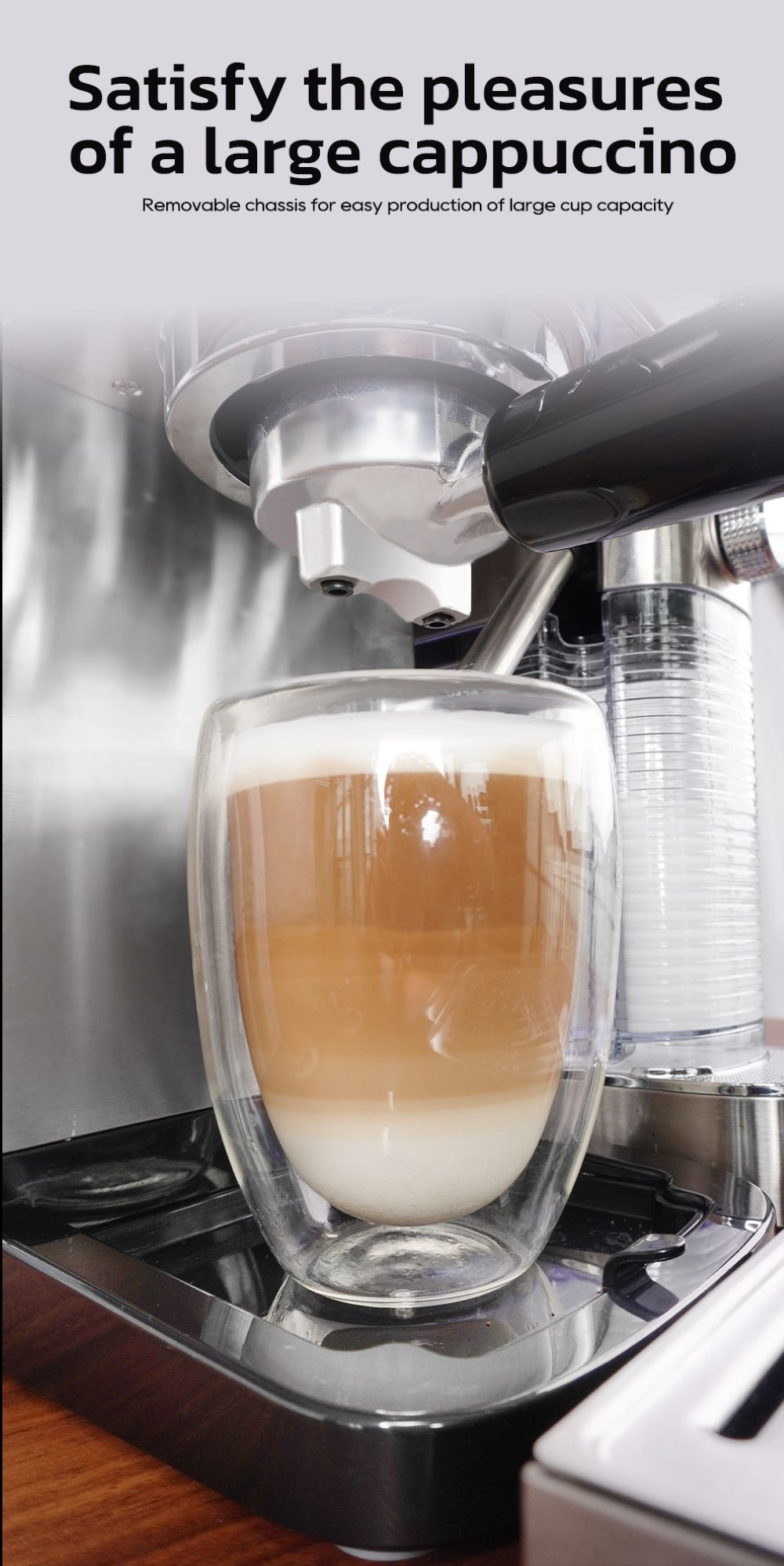 Un capuchino grande con capas de leche y café en un vaso de doble pared se asienta en una máquina de espresso.