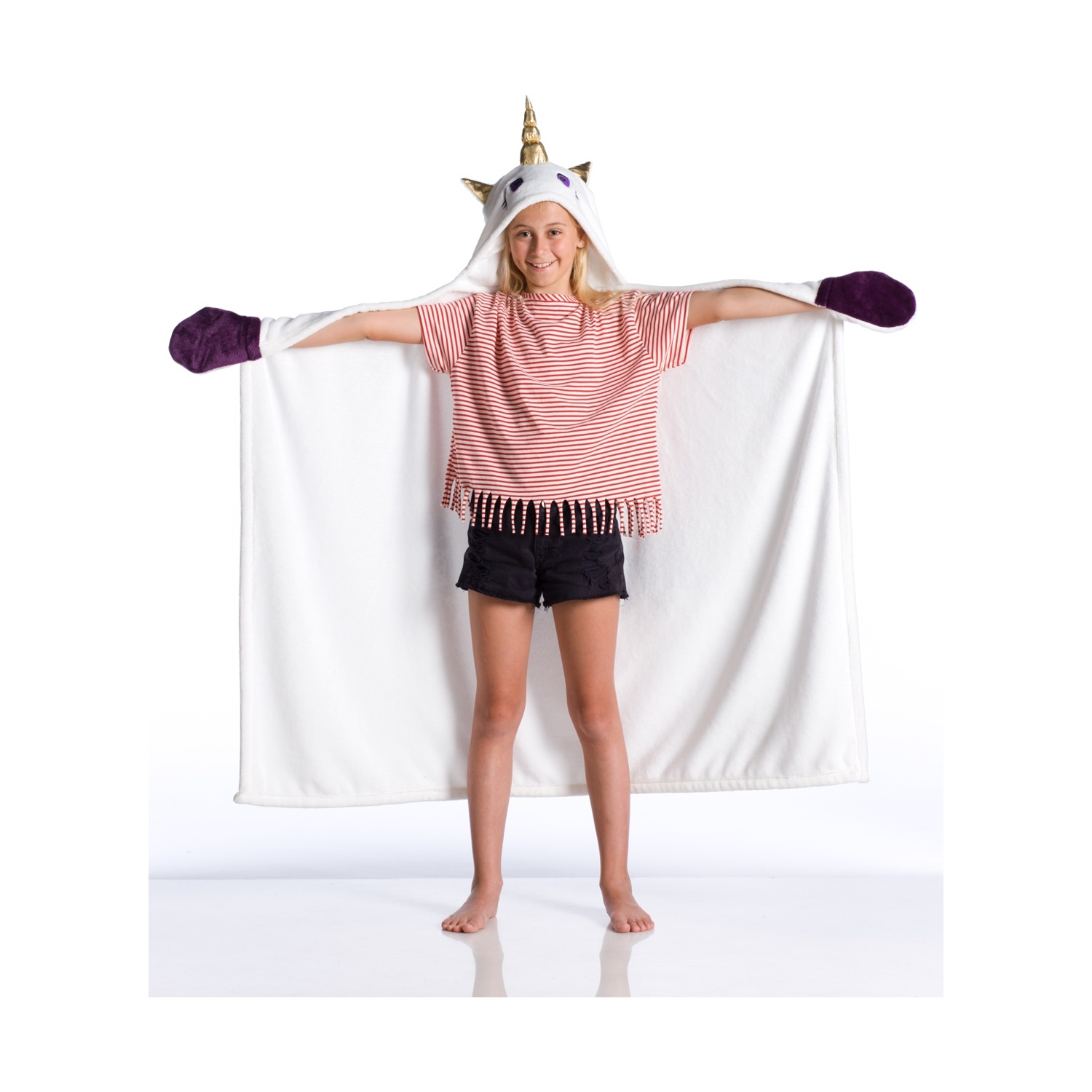 Una bambina in una coperta con cappuccio da unicorno sorride, indossa una maglietta a righe e pantaloncini neri.