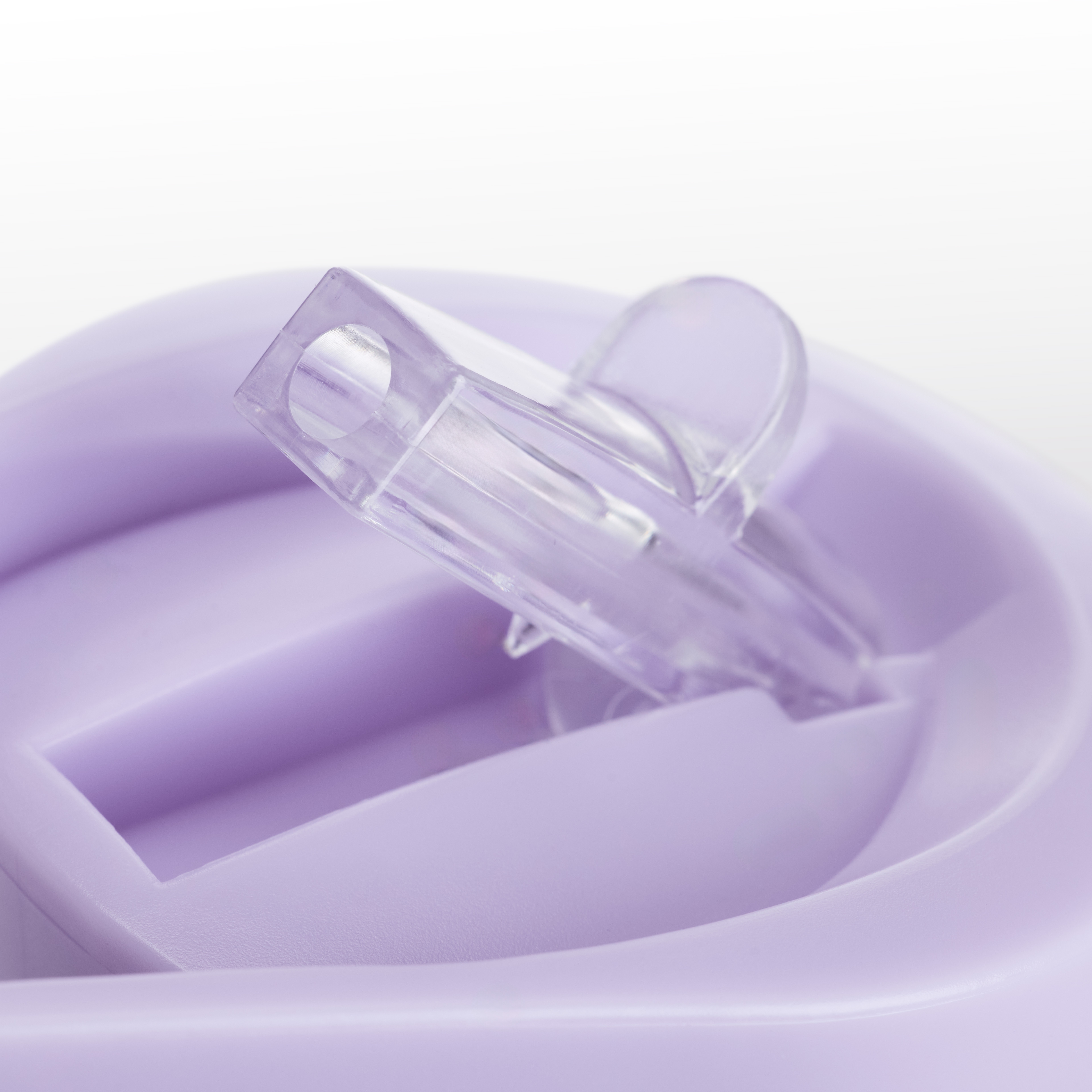 Un coperchio viola trasparente per bicchierino su una superficie viola.