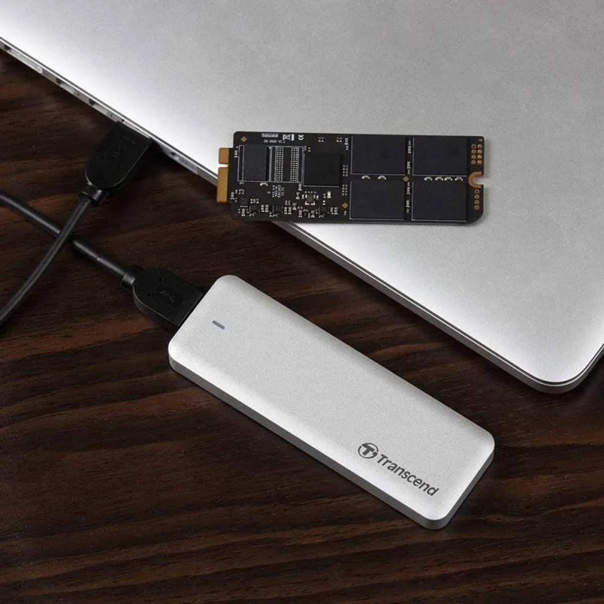 Un SSD esterno Transcend argentato e un SSD nero sono collegati a un laptop.