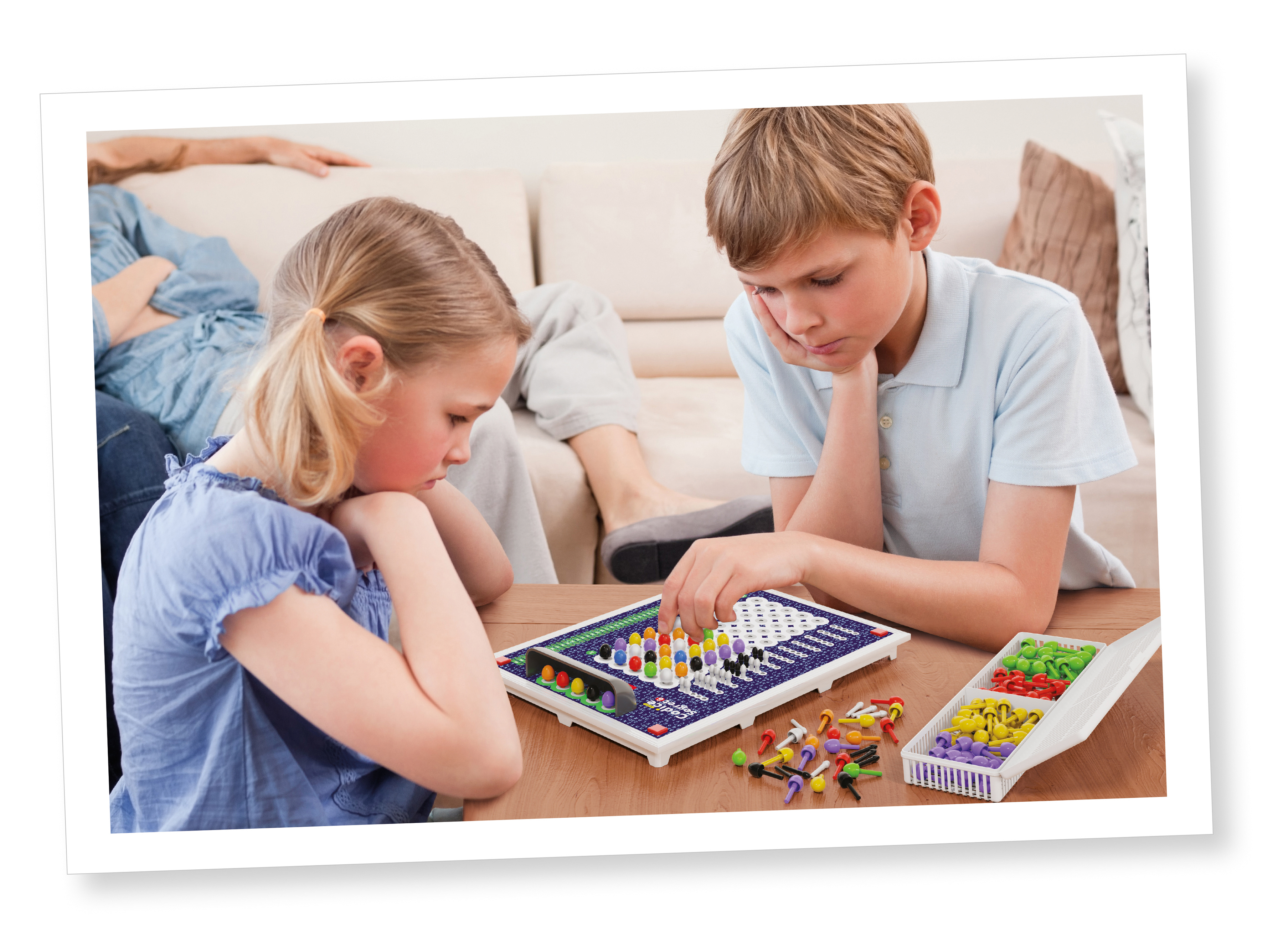 Due bambini giocano a un gioco da tavolo con pioli colorati su un tavolo di legno.