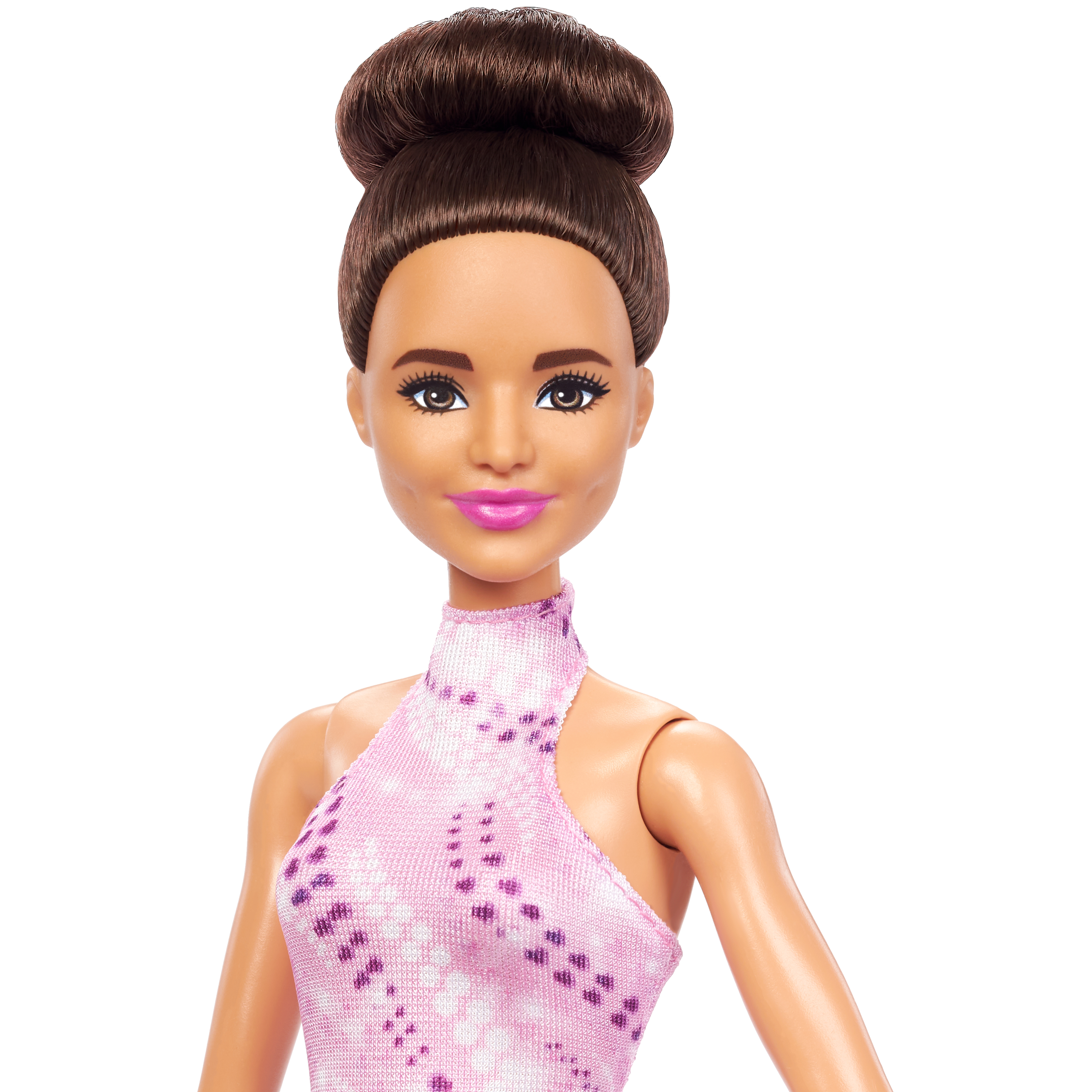 Primo piano di una bambola Barbie con i capelli raccolti a chignon, indossa un vestito rosa.