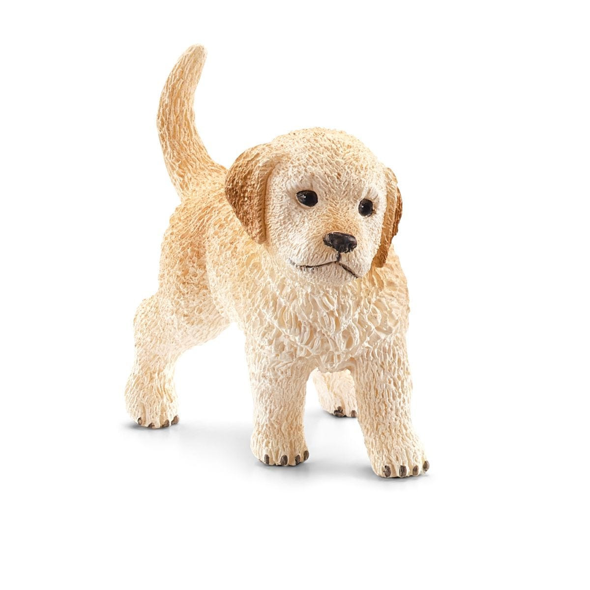 Un cucciolo Schleich Golden Retriever marrone chiaro sta su sfondo bianco.