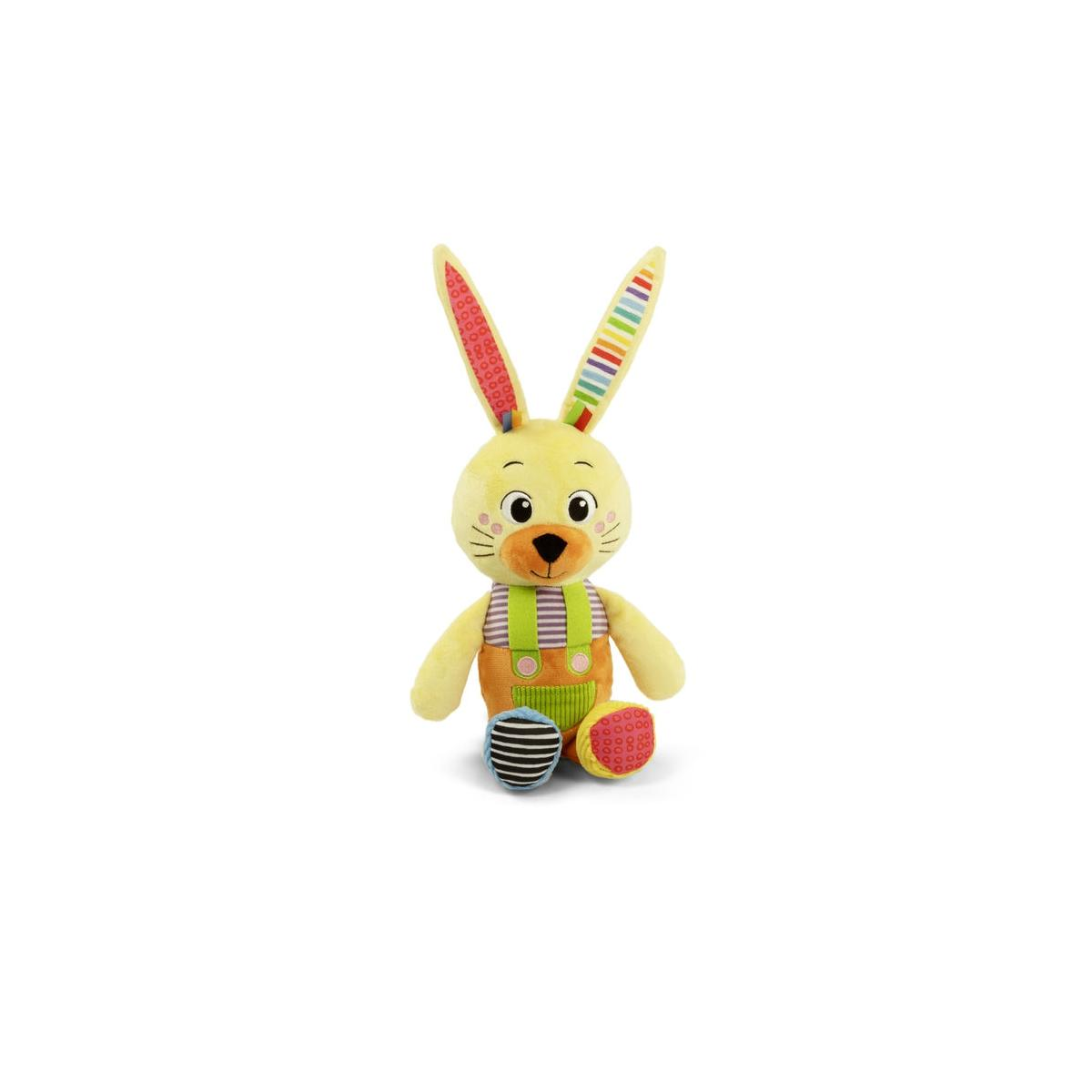 Un coniglietto di peluche giallo con salopette a righe seduto su sfondo bianco.