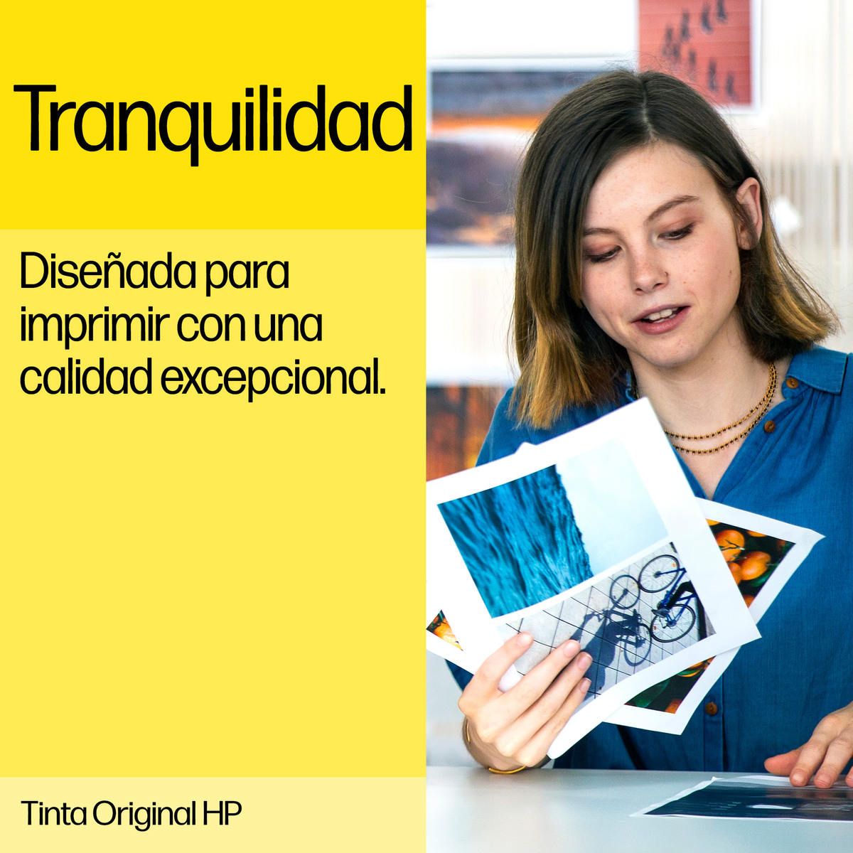 Donna con camicia blu tiene foto. Testo giallo a sinistra: Tranquilidad, Progettato per una qualità di stampa eccezionale.