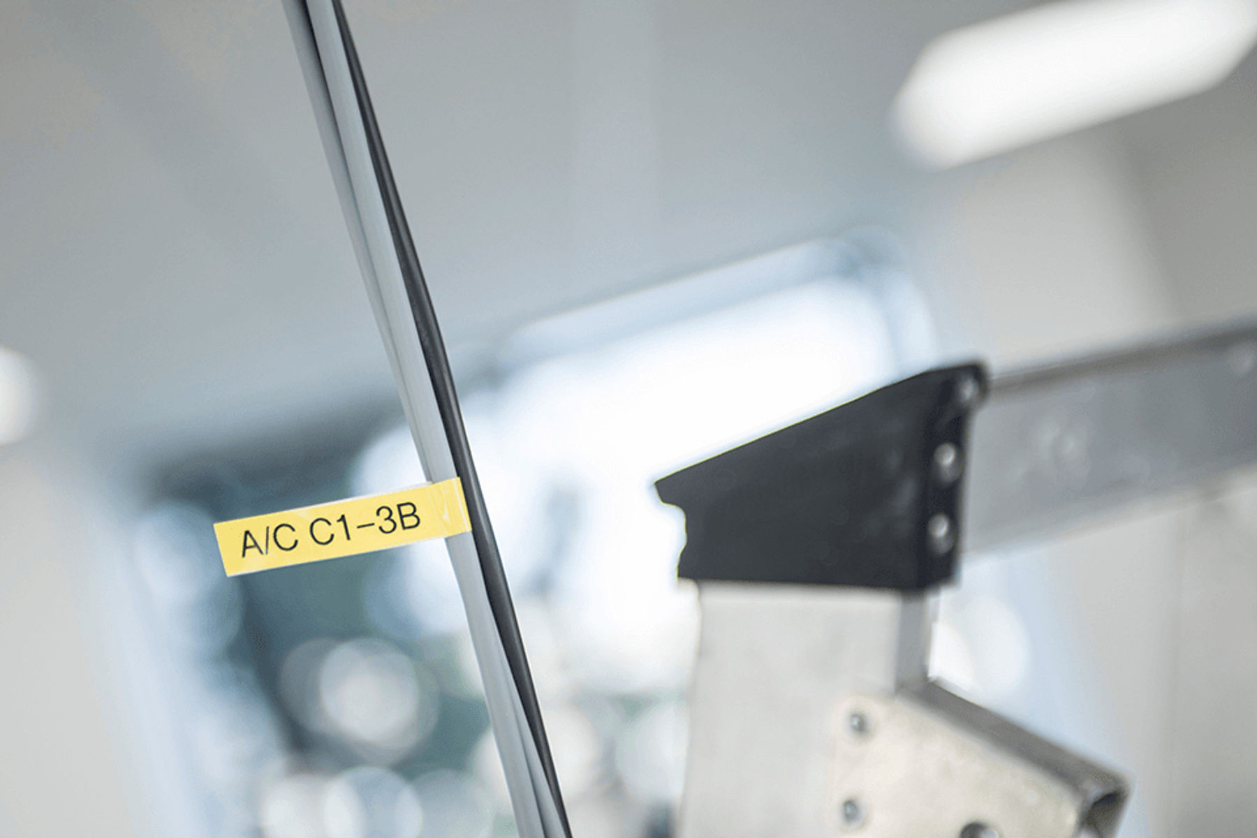 Un adesivo giallo con la dicitura "A/C C1-3B" è attaccato a un pannello.