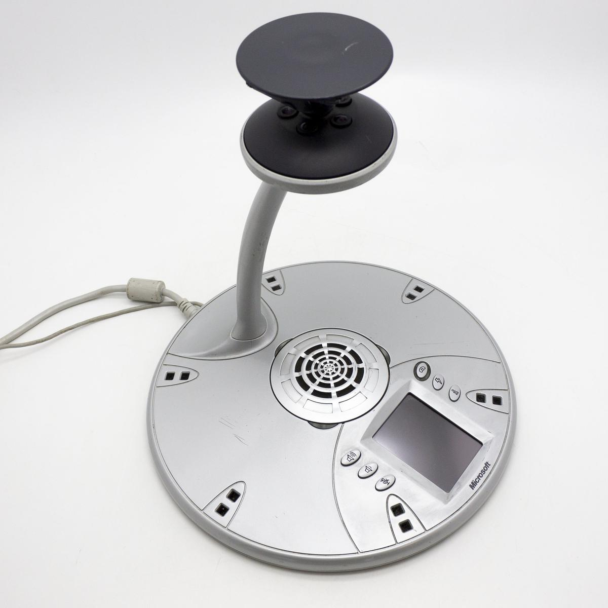 Una webcam Microsoft argentata con collo flessibile e base rotonda con schermo.