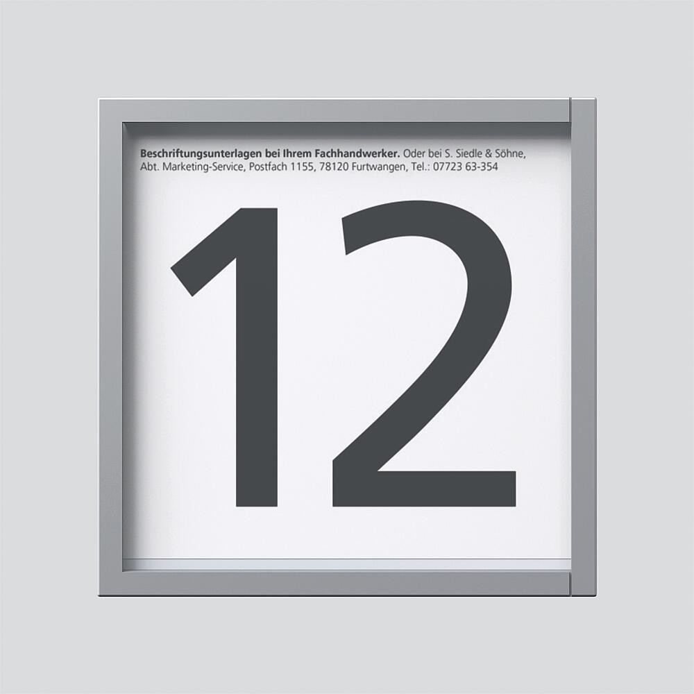 Un cartello con il grande numero 12 grigio scuro su sfondo bianco. Testo sopra.