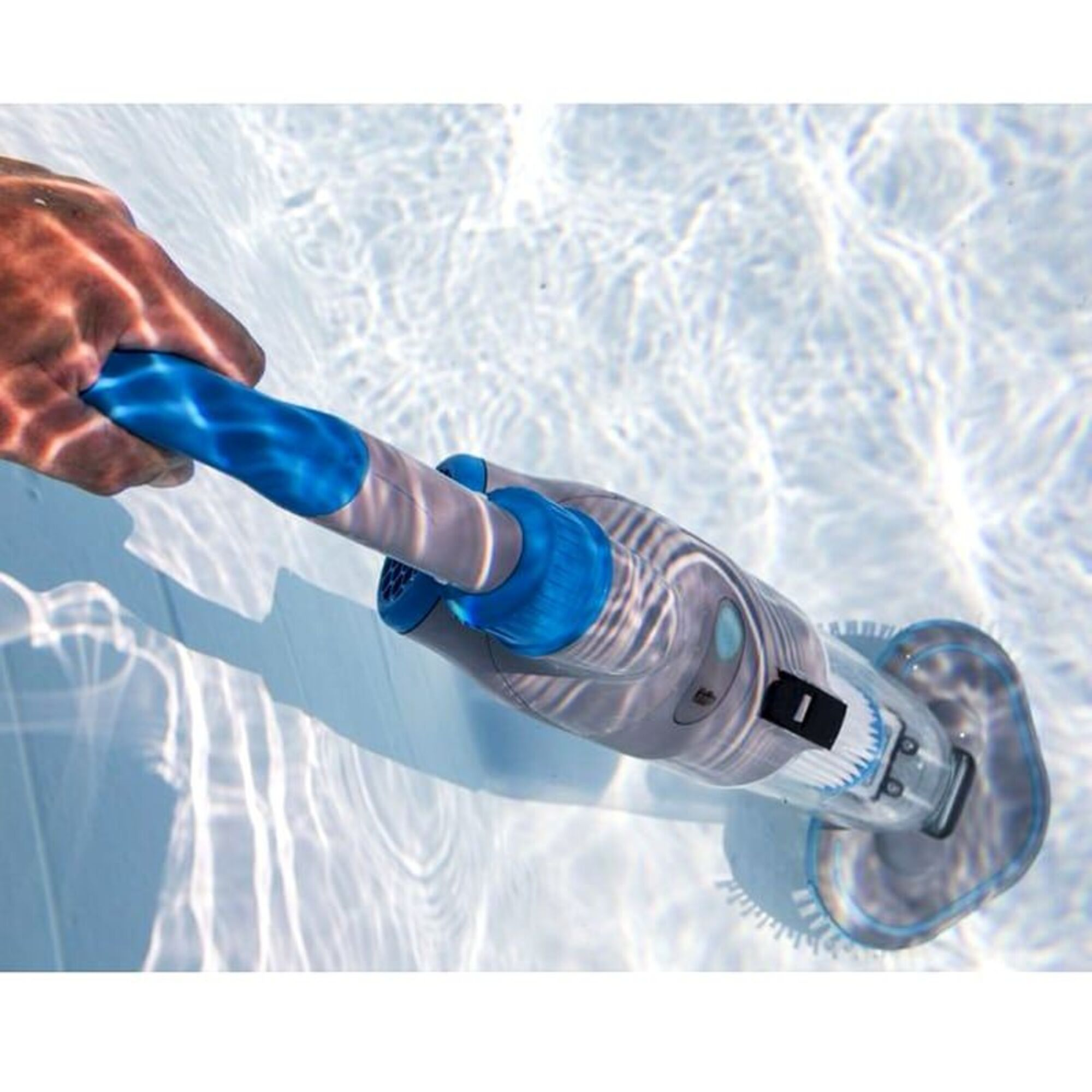 Eine Hand hält einen blau-grauen Pool-Sauger unter Wasser in klarem blauem Wasser.