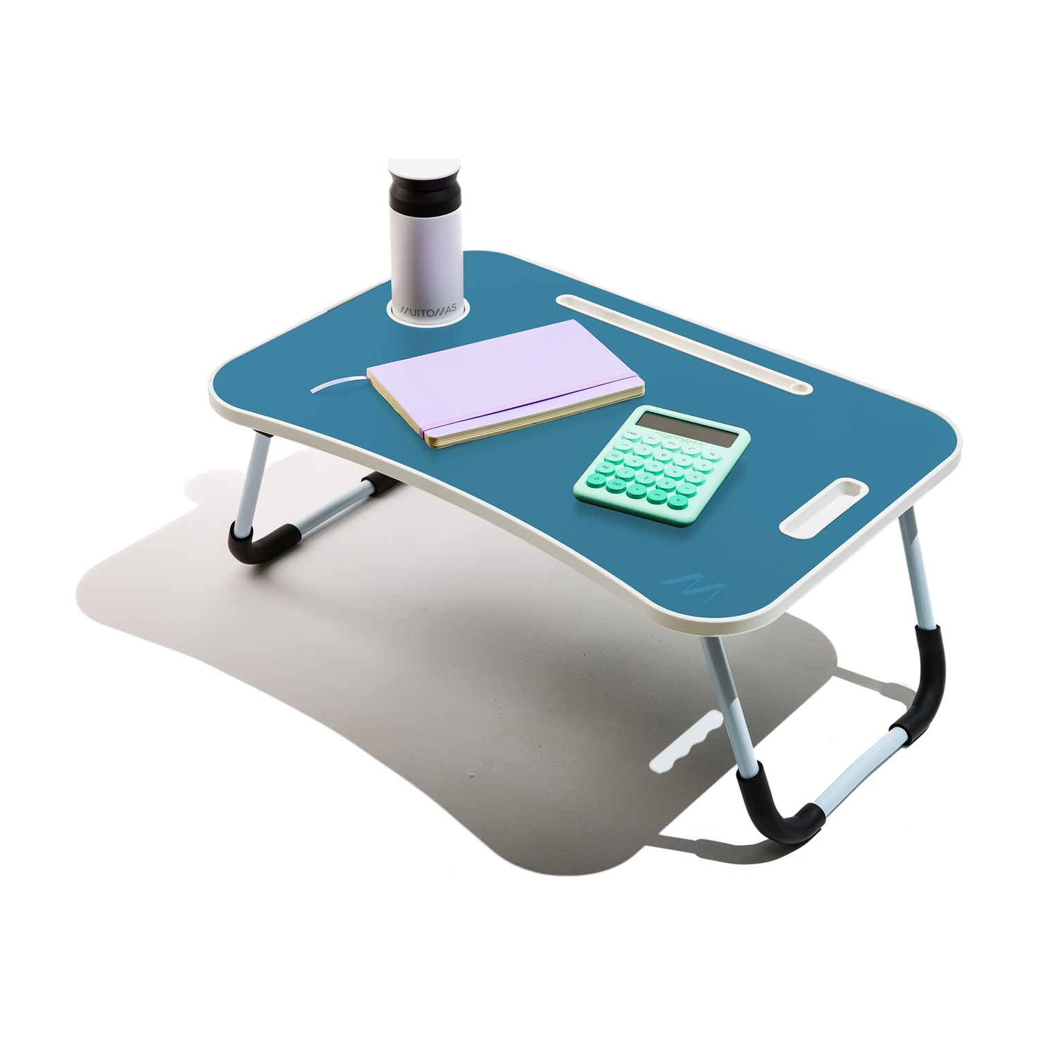 Un tavolino blu da grembo con taccuino, calcolatrice e tazza su sfondo bianco.