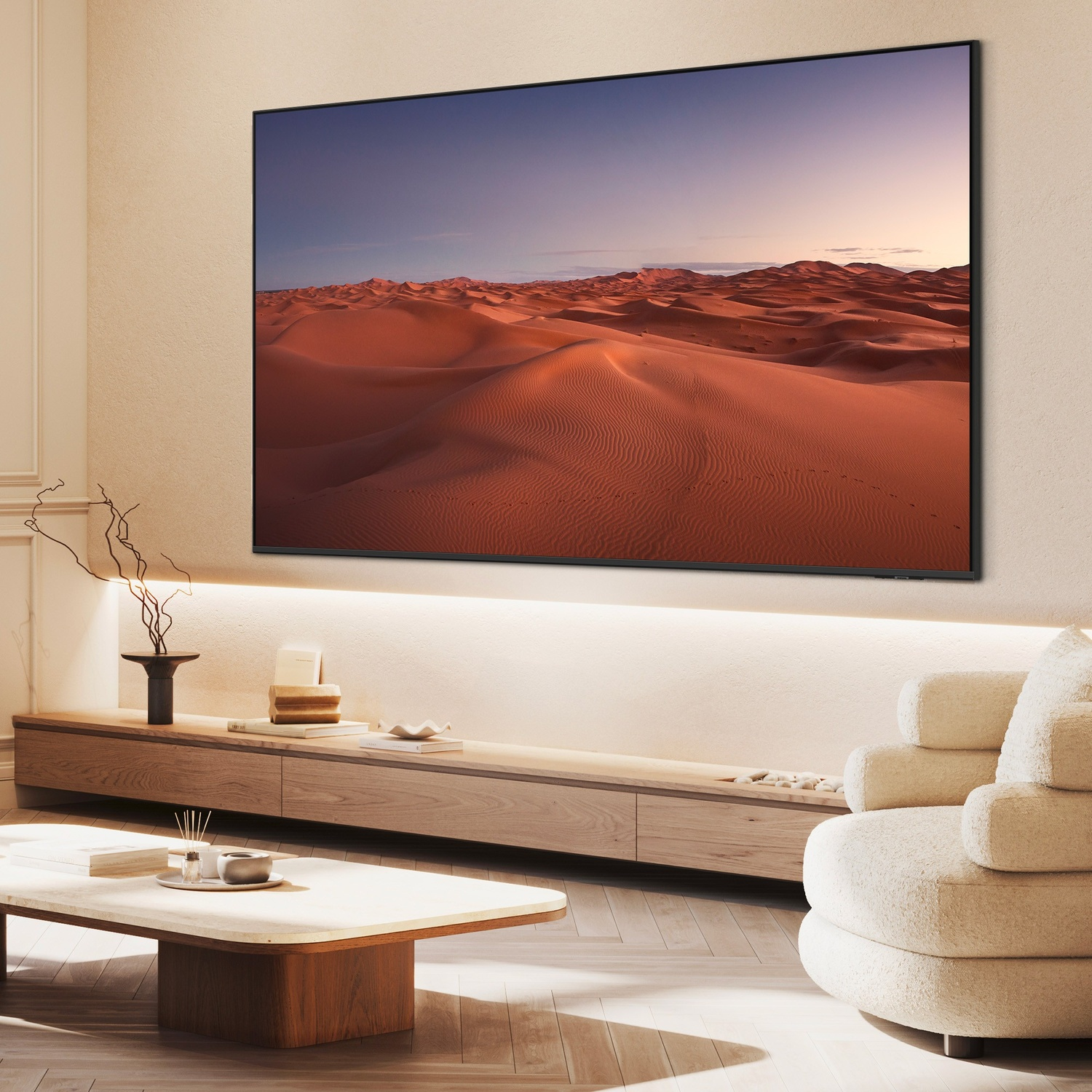 Un soggiorno moderno con un grande televisore che mostra un paesaggio desertico al tramonto.