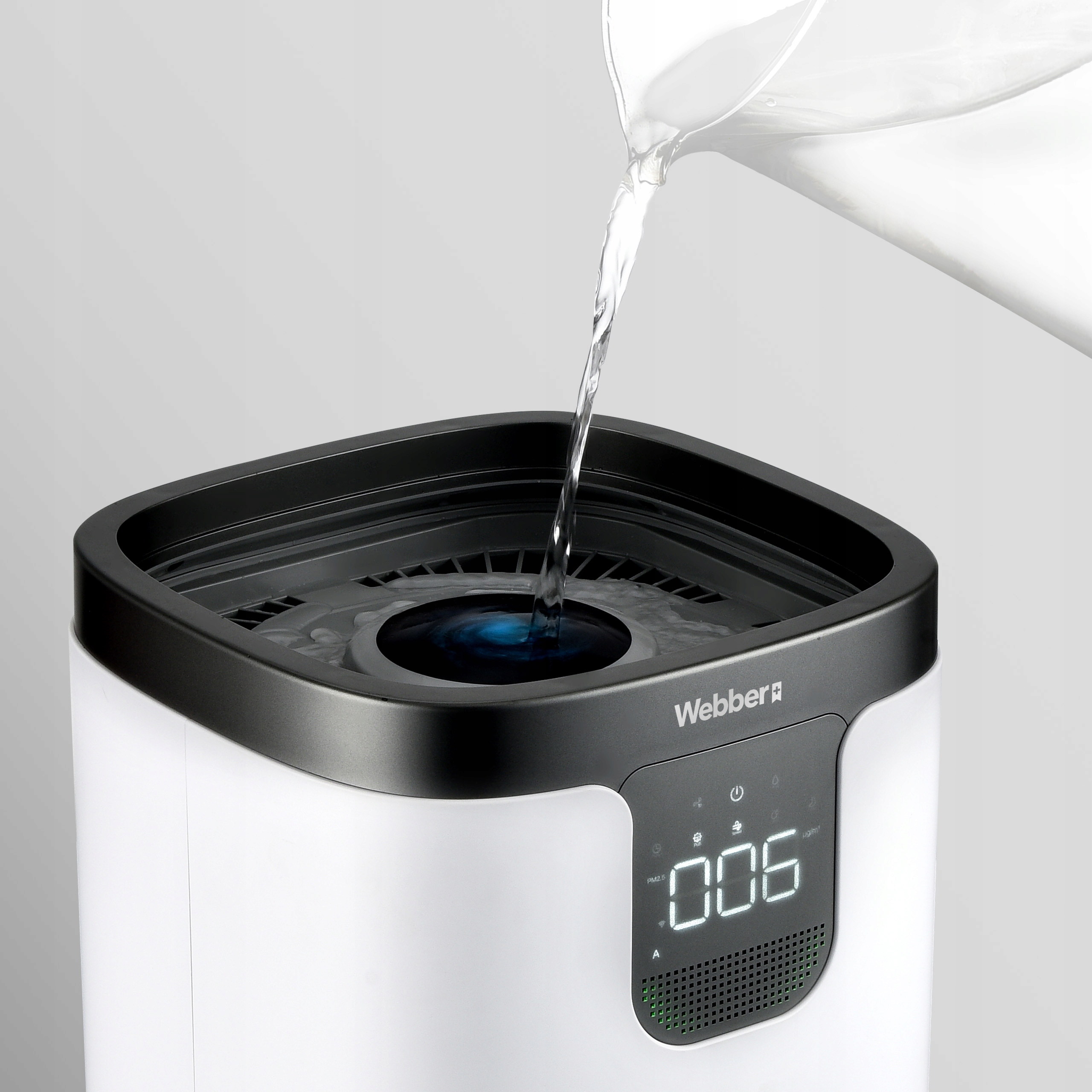 Woda jest wlewana do białego nawilżacza z cyfrowym wyświetlaczem.