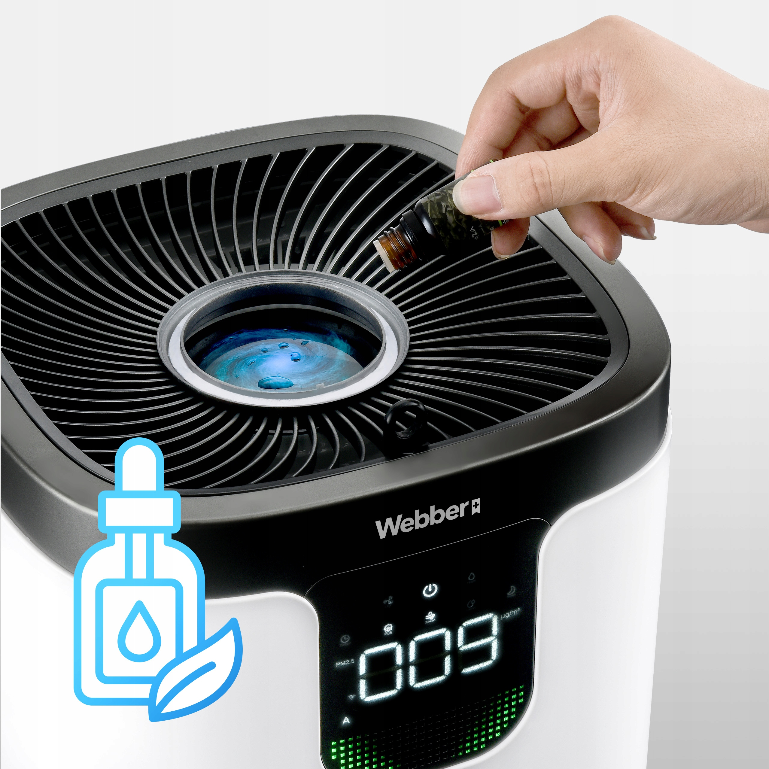 Ręka dodaje olejek eteryczny do oczyszczacza powietrza Webber z cyfrowym wyświetlaczem.