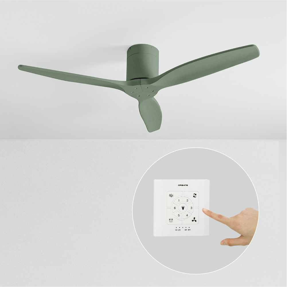 Un ventilador de techo verde salvia con tres aspas está montado en un techo blanco. Debajo, una mano presiona botones en un mando a distancia blanco.
