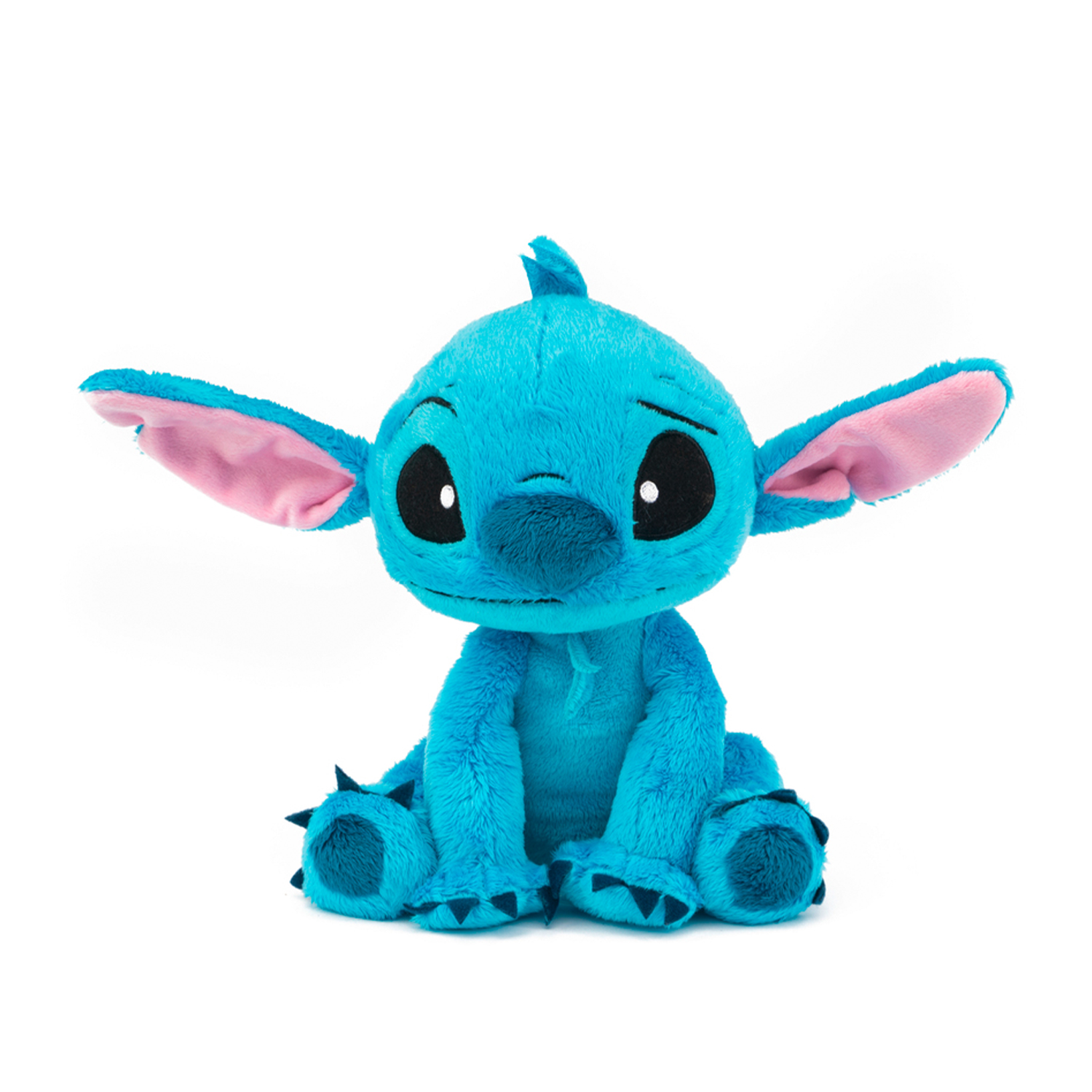 Une peluche bleue de Stitch avec de grandes oreilles et des yeux noirs est assise.