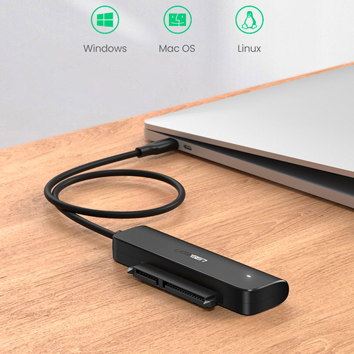 Czarny adapter SATA na USB podłączony do laptopa. Kompatybilny z Windows, Mac OS, Linux.