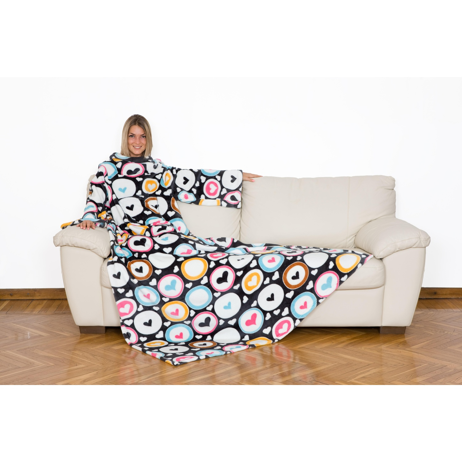 Donna su un divano che indossa una coperta con motivo a cuori e cerchi.