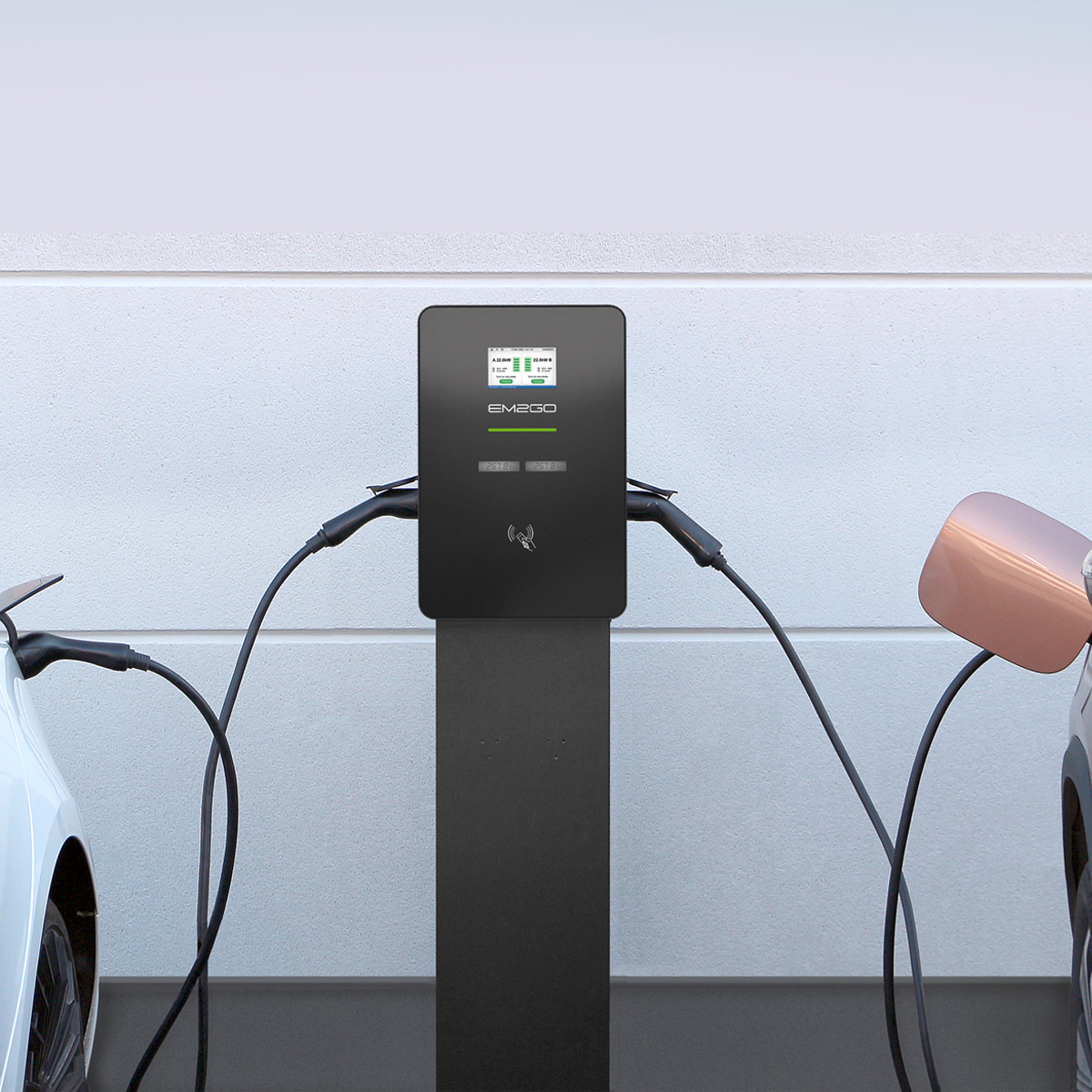 Zwei Elektroautos werden an einer Ladestation geladen. Vorne links ein weißes Auto, rechts ein kupferfarbenes.