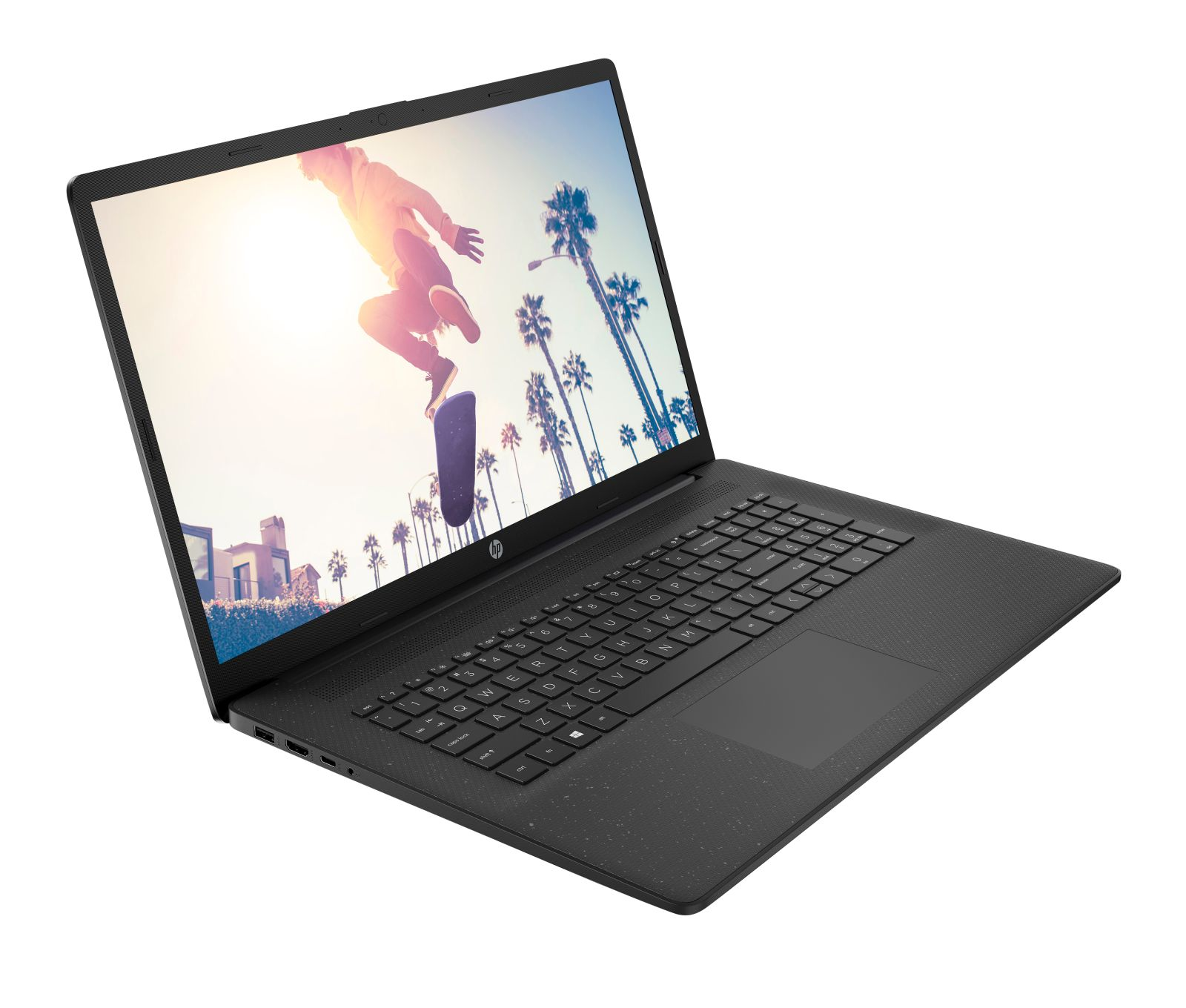 Czarny laptop HP z deskorolkarzem skaczącym przed palmami.