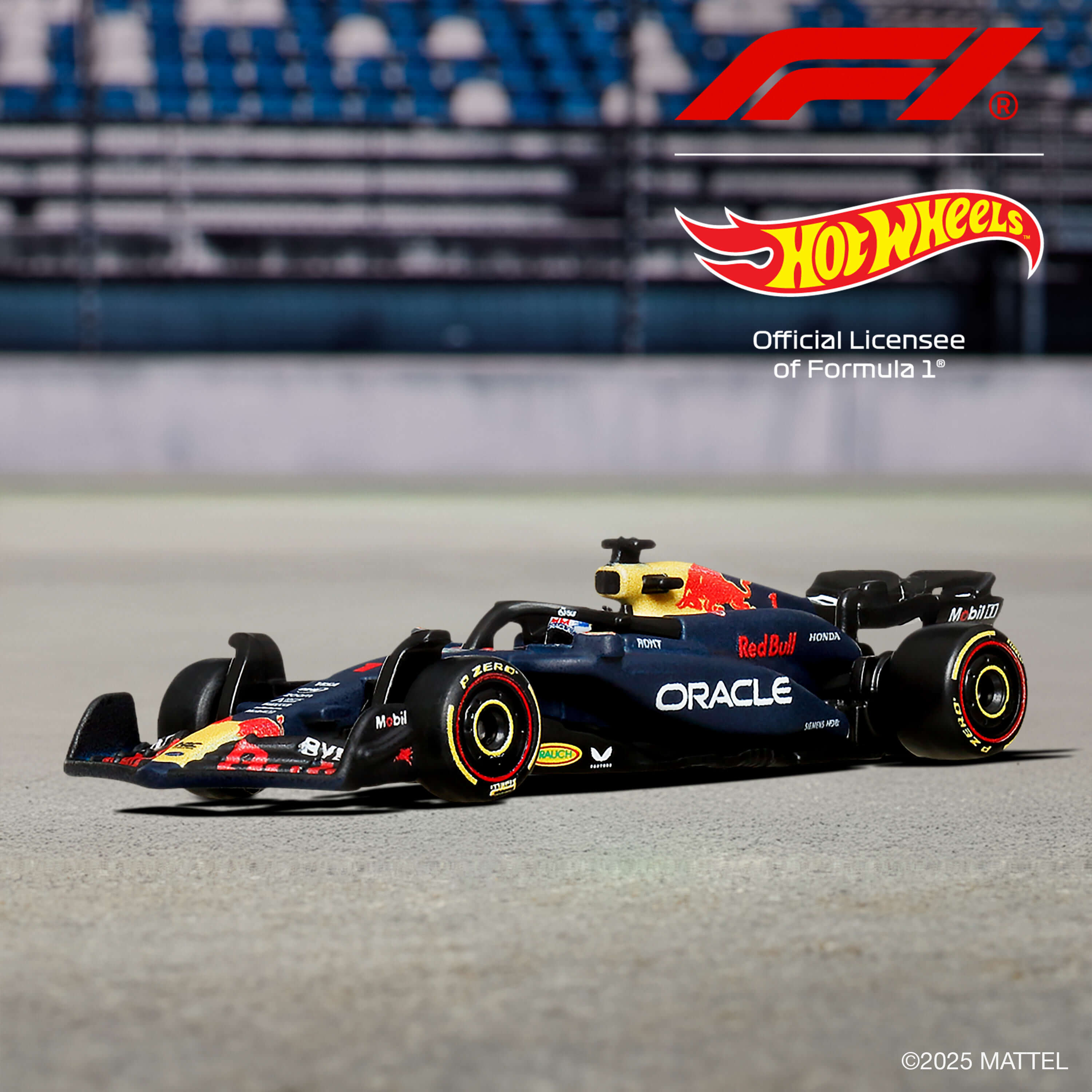 Un coche de carreras de Fórmula 1 rojo y azul con logos de Hot Wheels y F1 sobre una superficie gris.