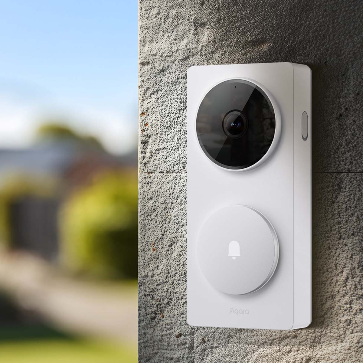 Un videocitofono smart bianco con telecamera e icona a campana è montato su un muro testurizzato.
