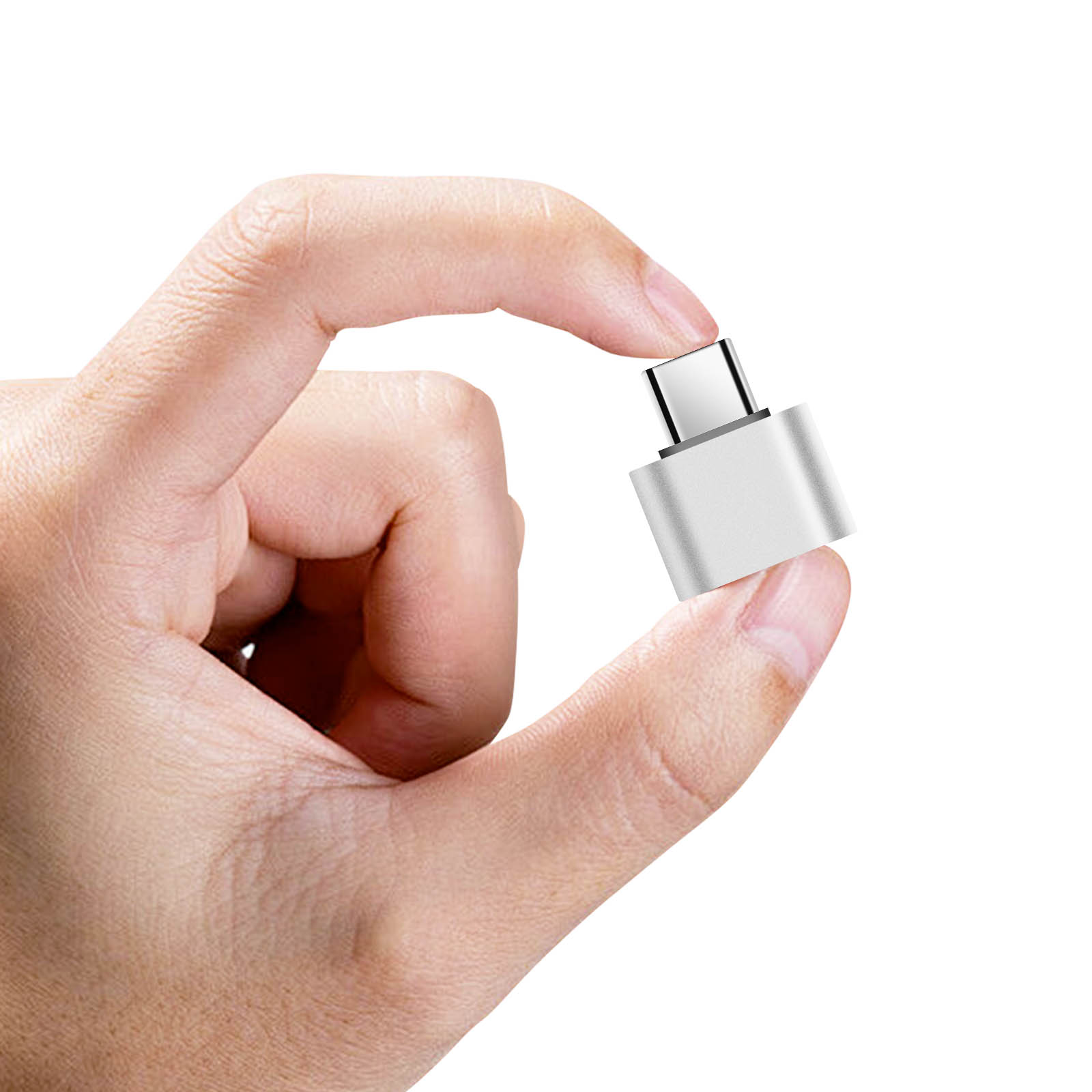 Un adattatore USB-C argentato tenuto tra pollice e indice su sfondo bianco.