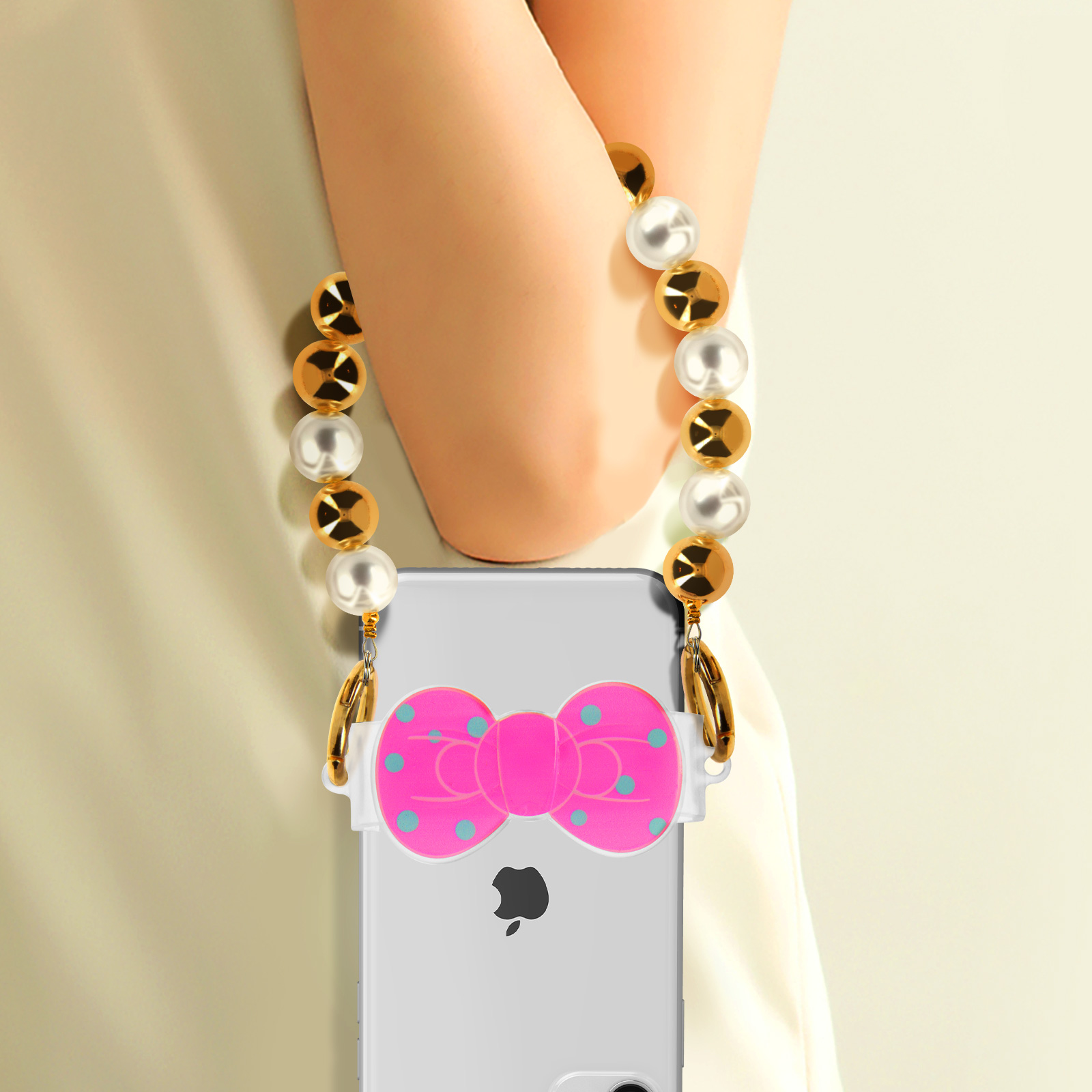 Uno smartphone con fiocco rosa e catena di perle al collo di una persona.