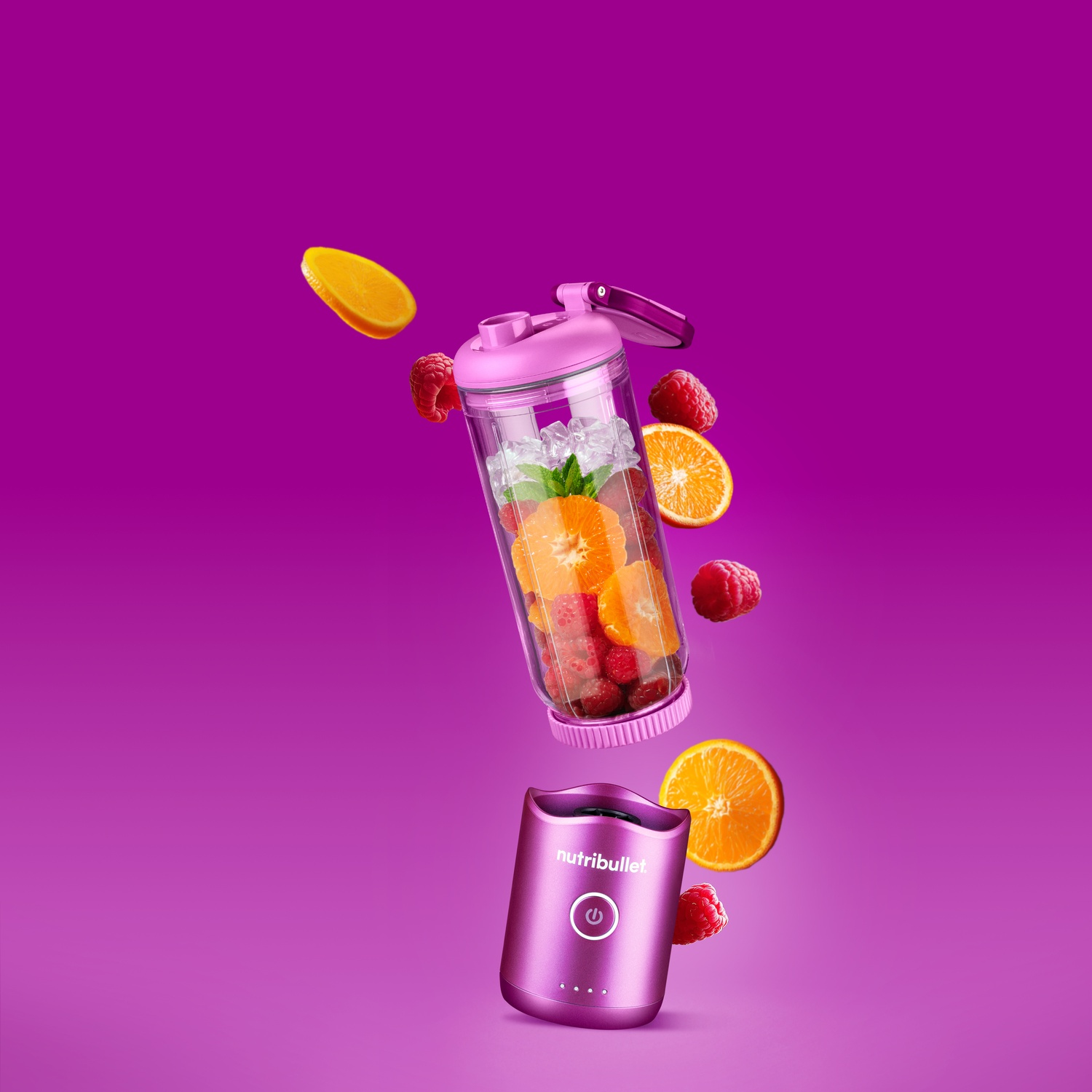 Un frullatore Nutribullet rosa con frutta e ghiaccio che fluttuano intorno.