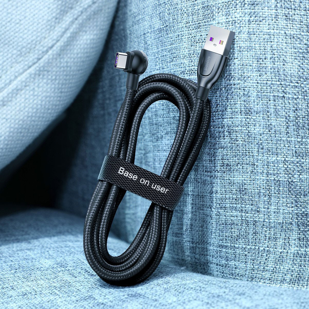 Cavo USB-C nero ad angolo di 90 gradi con connettore USB-A su tessuto blu.