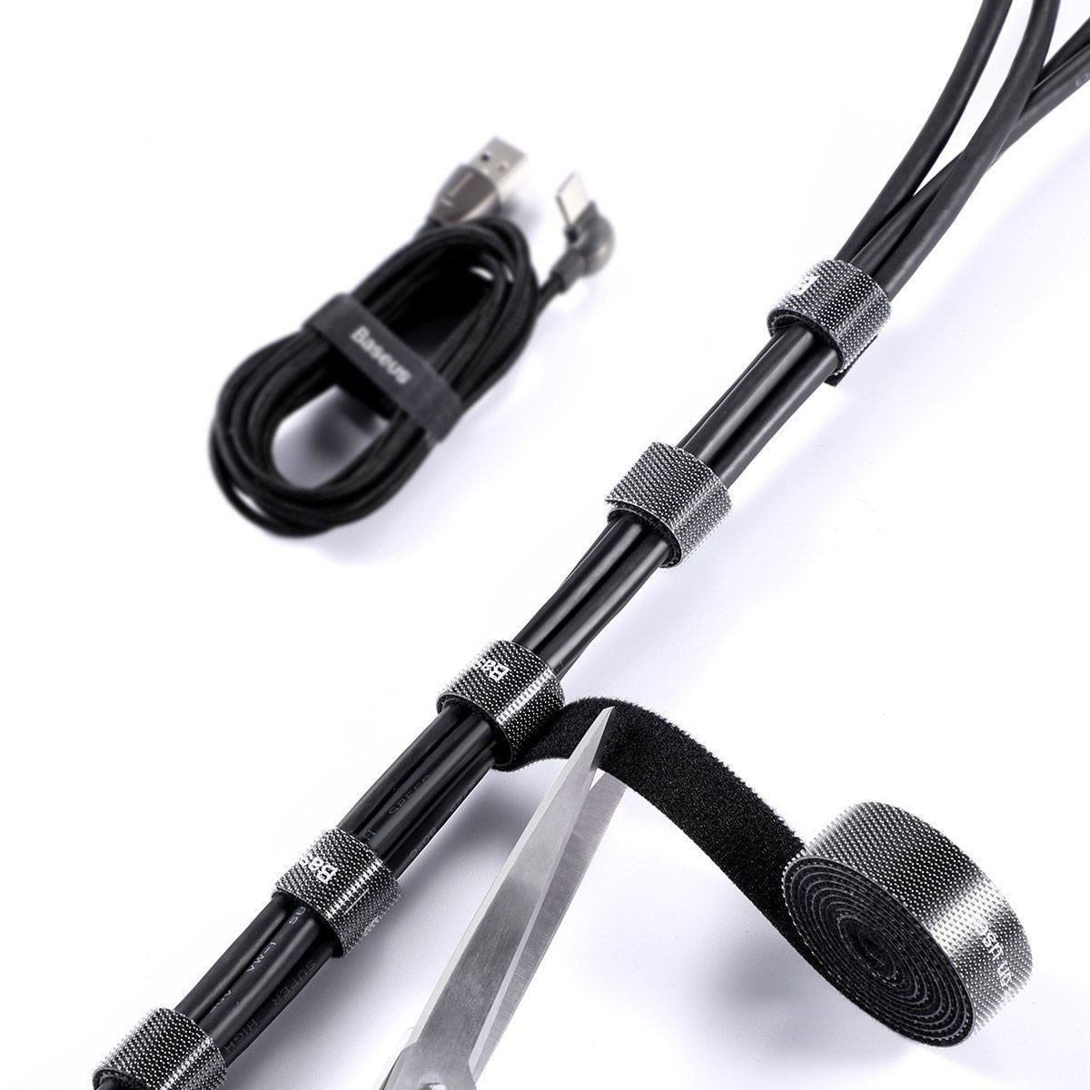Cavi neri fissati con fascette in velcro riutilizzabili. Forbici e rotolo di velcro visibili.