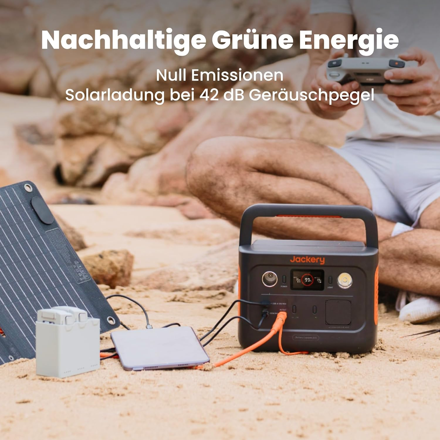Tragbarer Solargenerator, Akku und Panel auf Sand. Mann hält Controller.