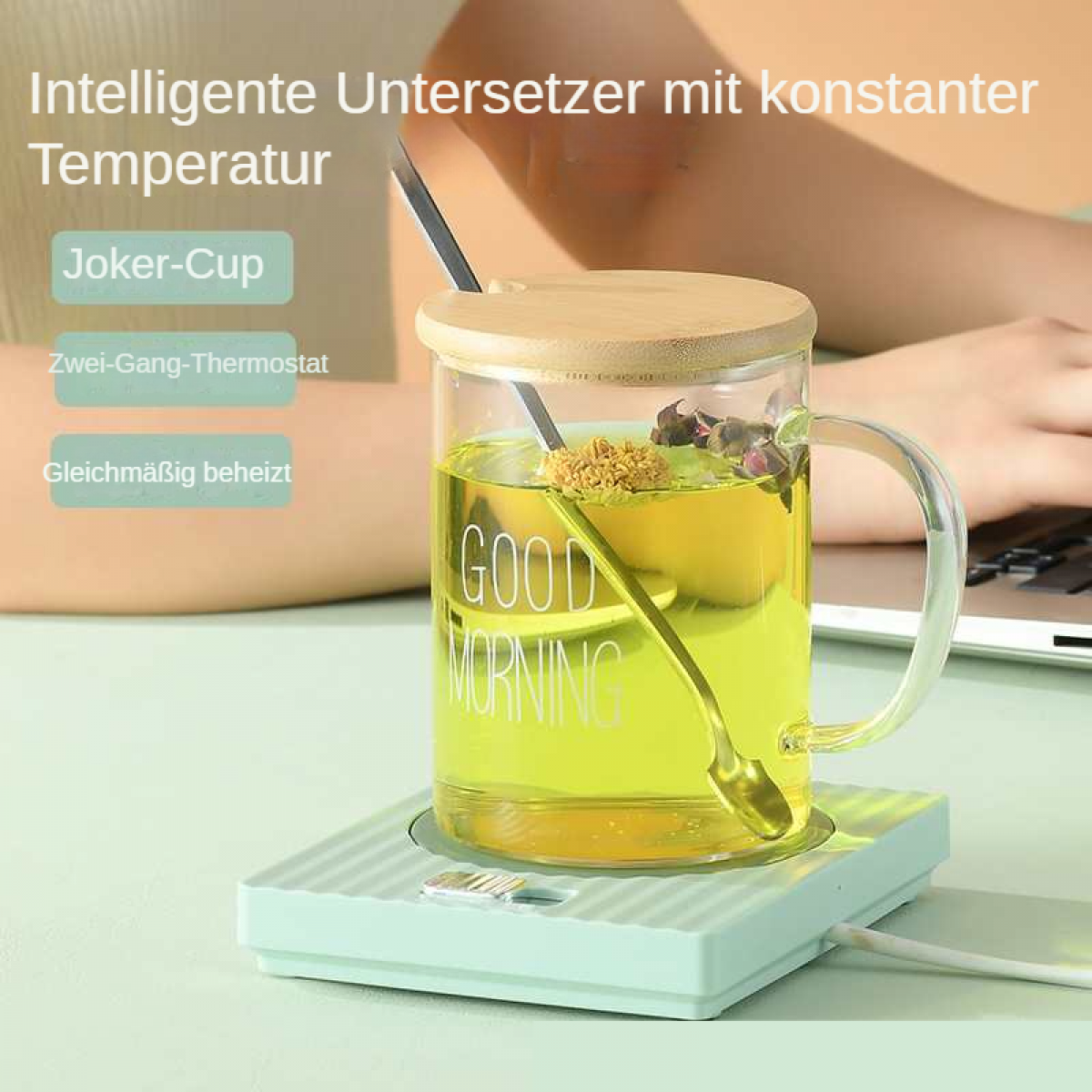 Eine Glastasse mit gelbem Tee steht auf einer grünen Untertasse. Text: Guten Morgen.