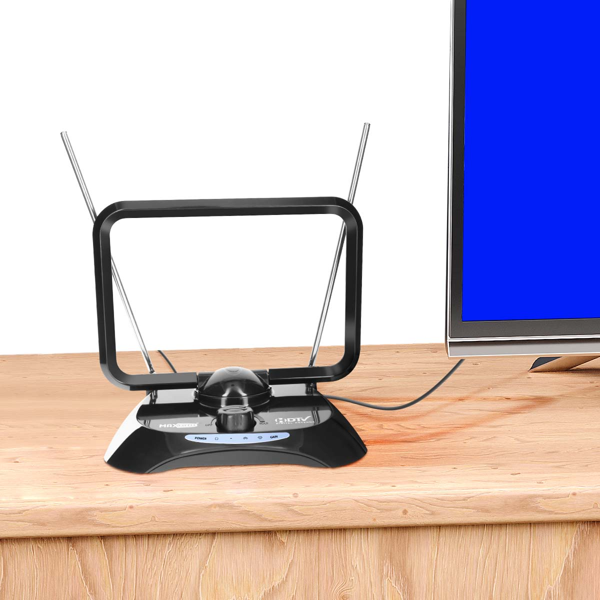 Eine schwarze HDTV-Antenne mit Teleskopstäben steht auf einem Holztisch neben einem Fernseher mit blauem Bildschirm.