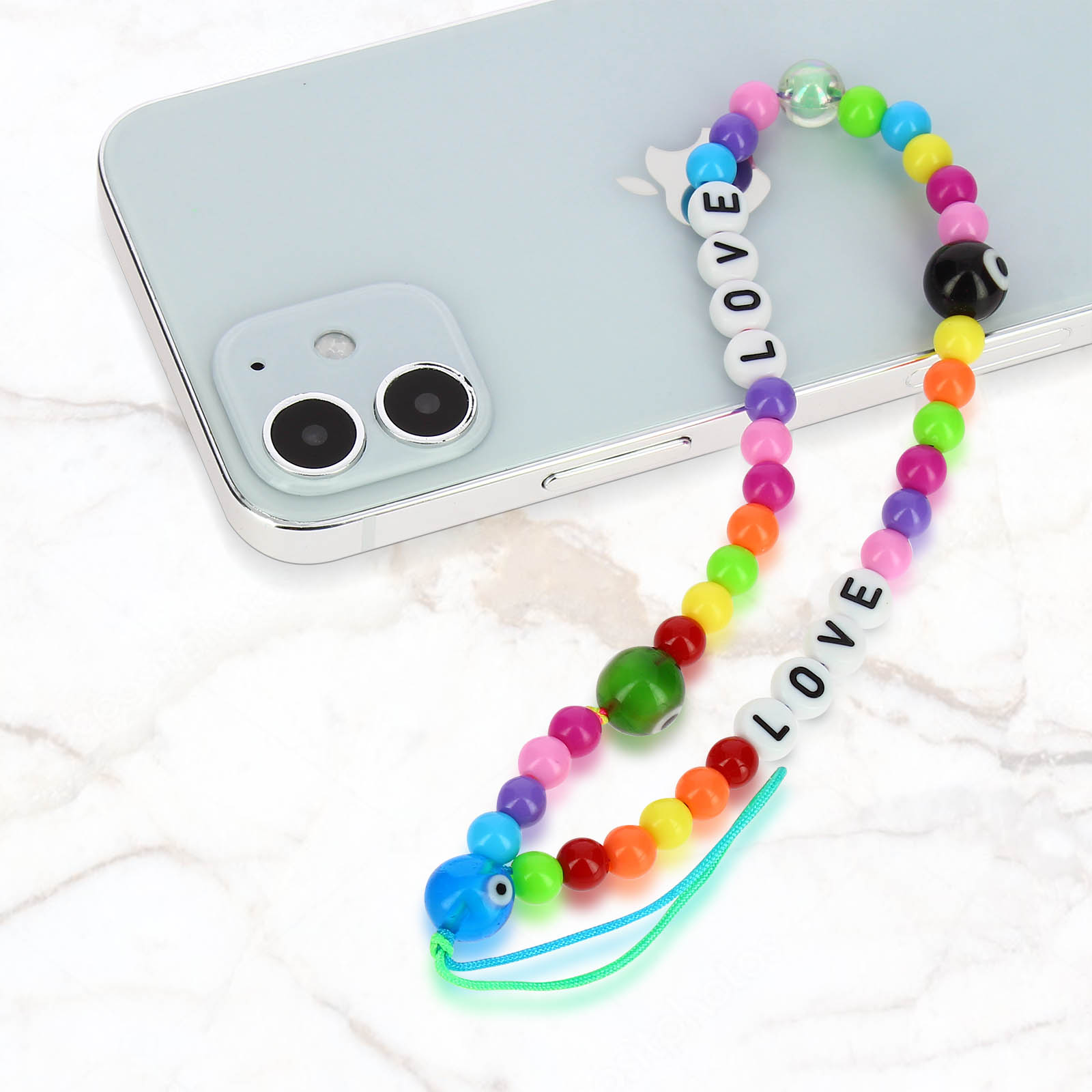 Un ciondolo colorato per telefono con perline con la parola LOVE scrive LOVE su un telefono azzurro.