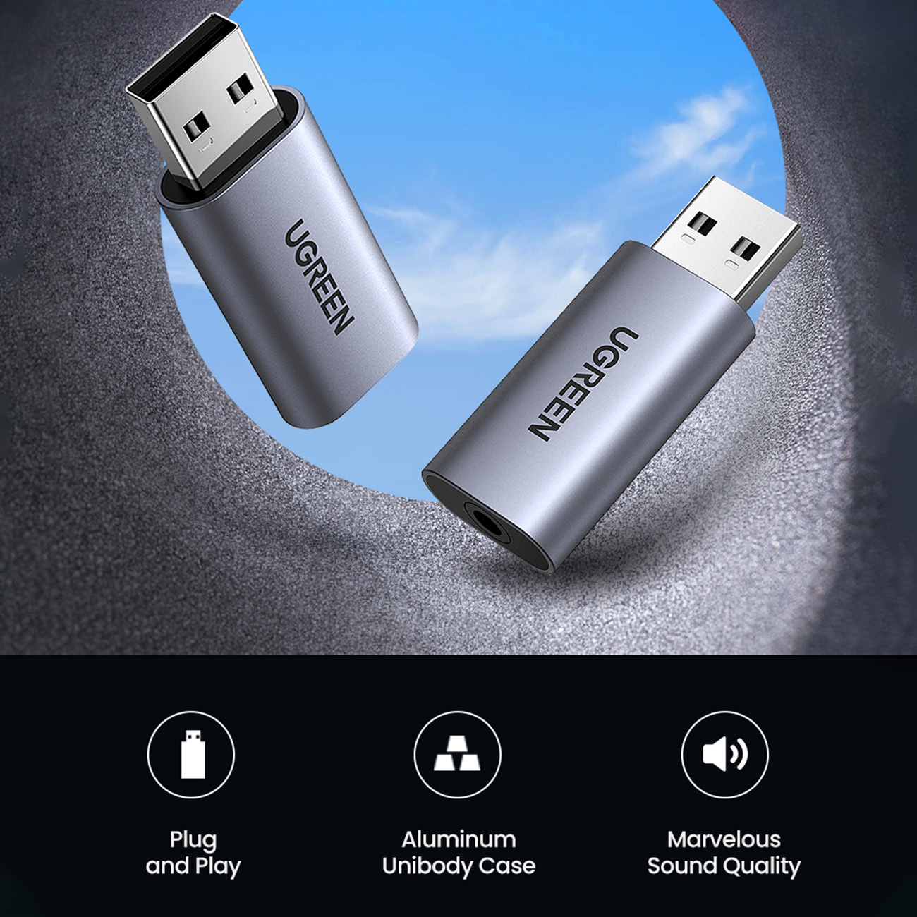 Dwa srebrne adaptery USB UGREEN ze złączami USB-A na tle niebieskiego nieba.