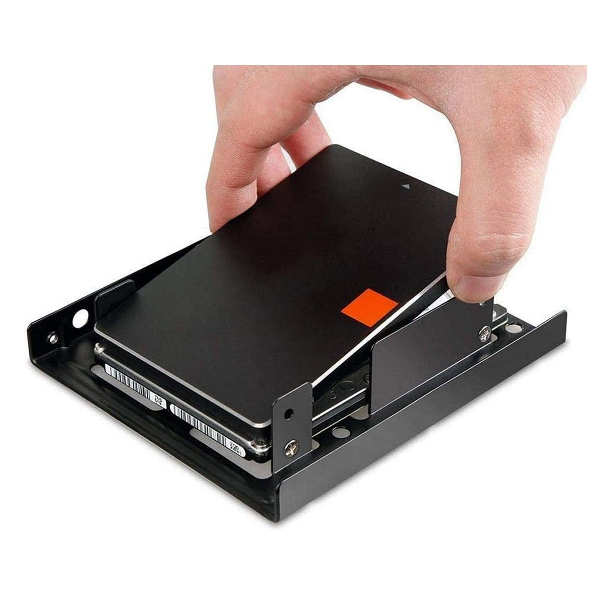 Una mano inserisce un SSD nero in una staffa metallica nera che tiene due HDD.