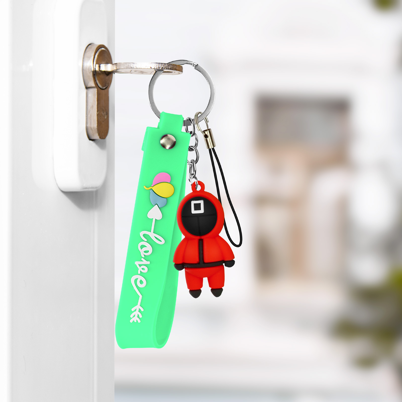 Portachiavi con personaggio rosso di Squid Game e cinturino verde con scritta "Love".